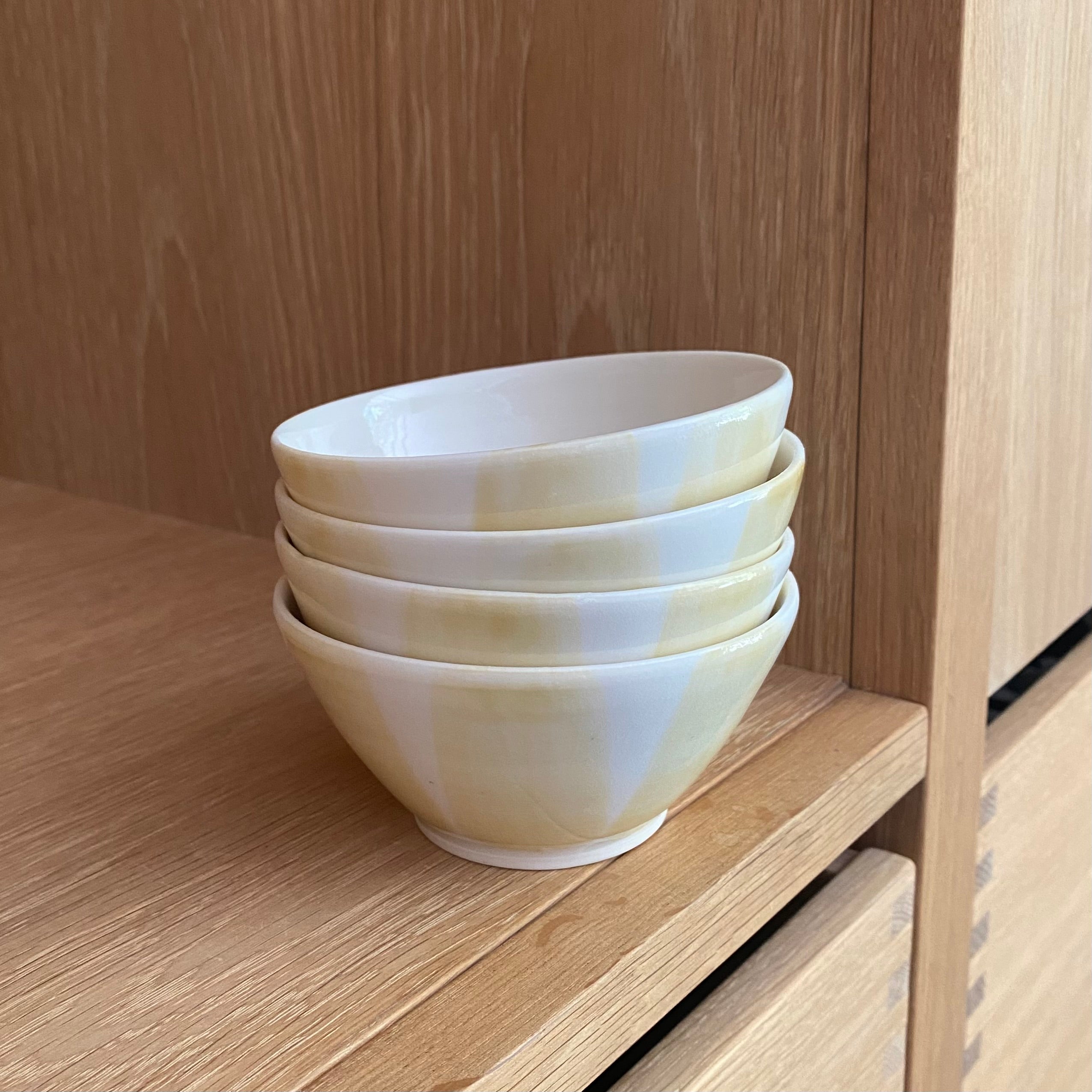 Morgenmadsskåle med gule striber i porcelæn – sæt af fire hånddrejede keramikskåle af Ann-Louise Roman