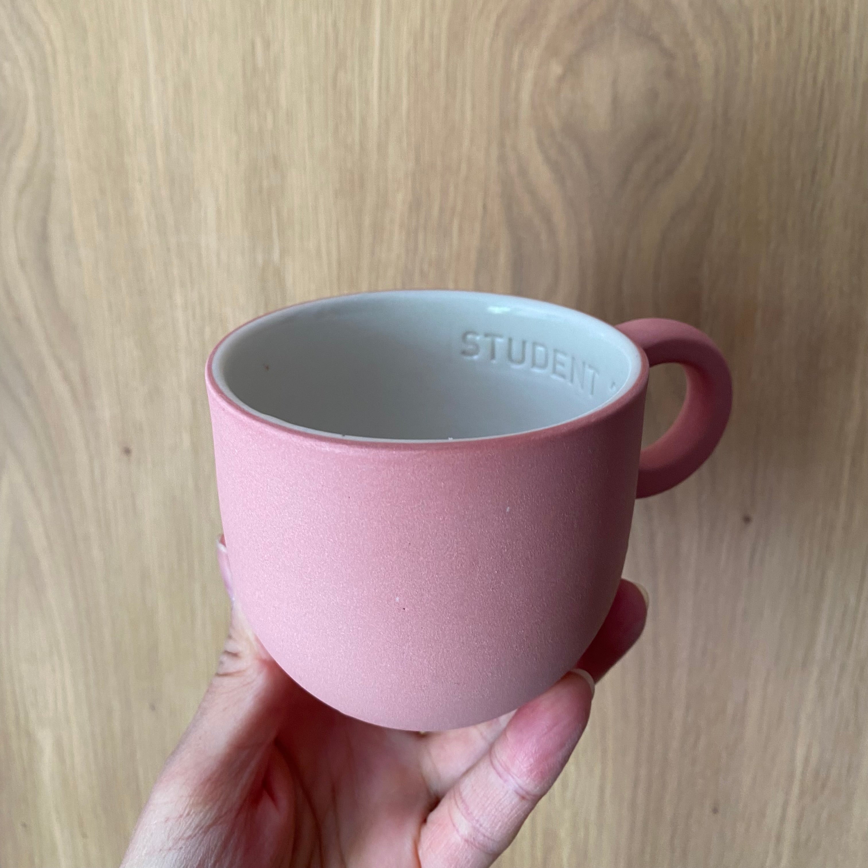 Chubby kaffekop med teksten Student 2026 i støvet hindbær – håndlavet porcelæn fra Helle Gram | Unika K