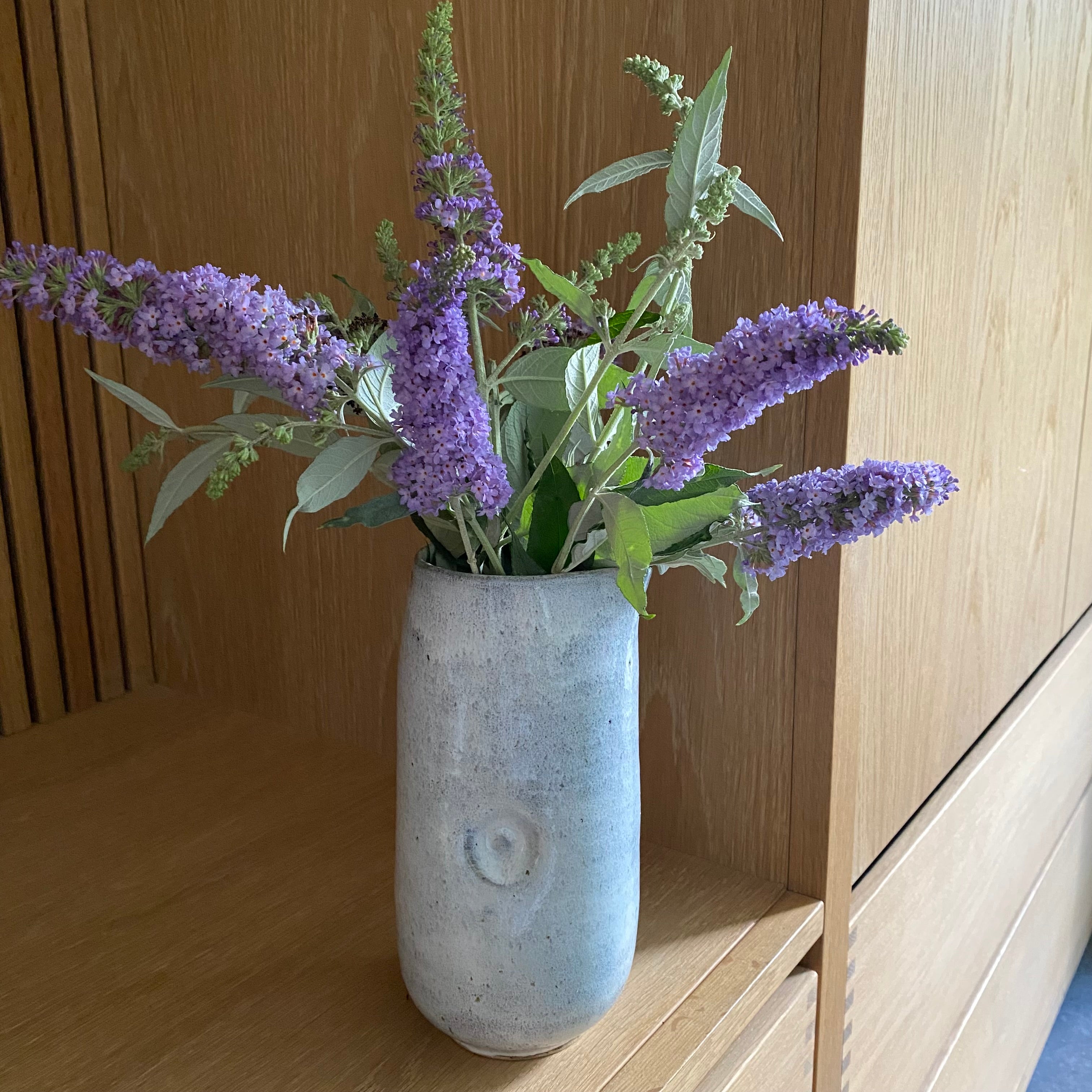 Keramikkande i lyseblå brugt som vase med blomster – dansk håndlavet keramik fra Tasja P ceramics