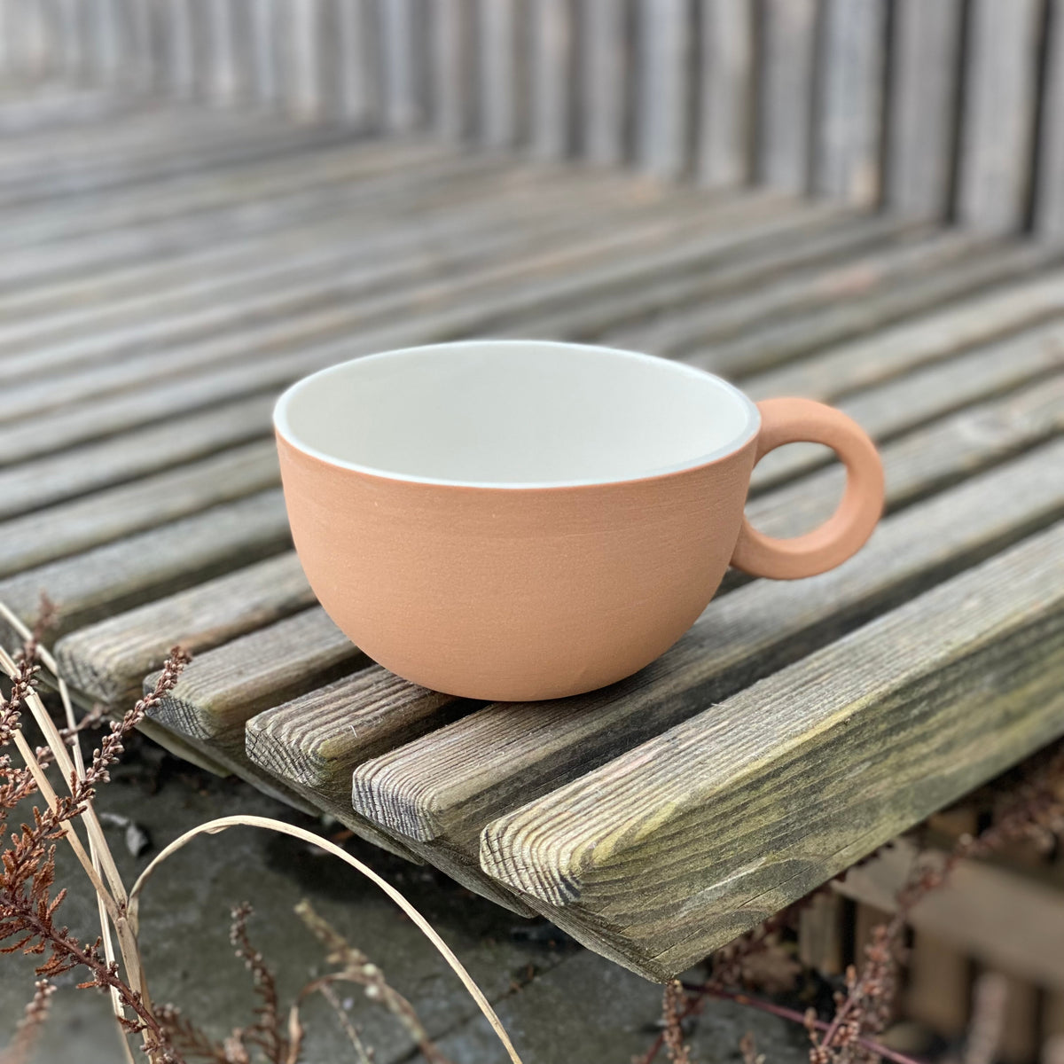 Tekop i blød orange fra Helle Gram i Chubby-design med rund hank.⠋