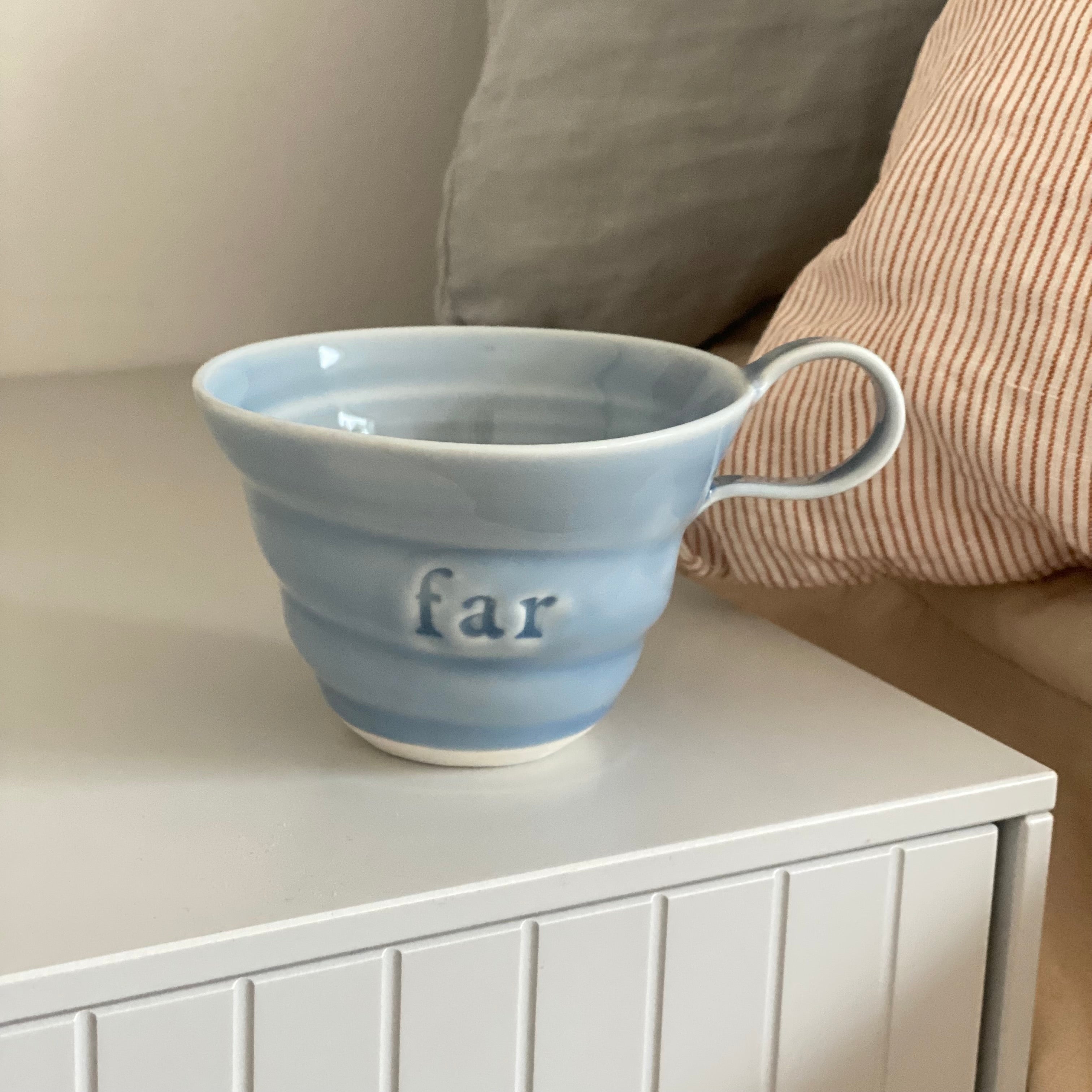 Dansk keramik – hånddrejet far kop i lyseblå porcelæn med spiralriller og teksten Far, skabt af Rikke Mangelsen