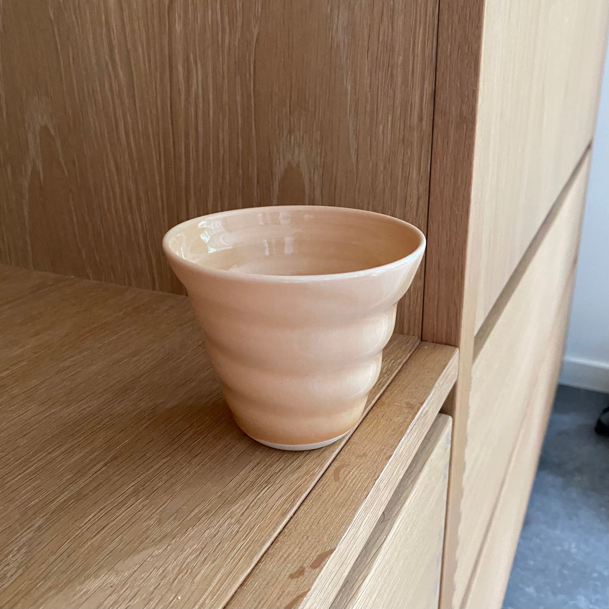 Håndlavet keramikkop i melonfarvet glasur – dansk spiralkop i porcelæn fra Rikke Mangelsen