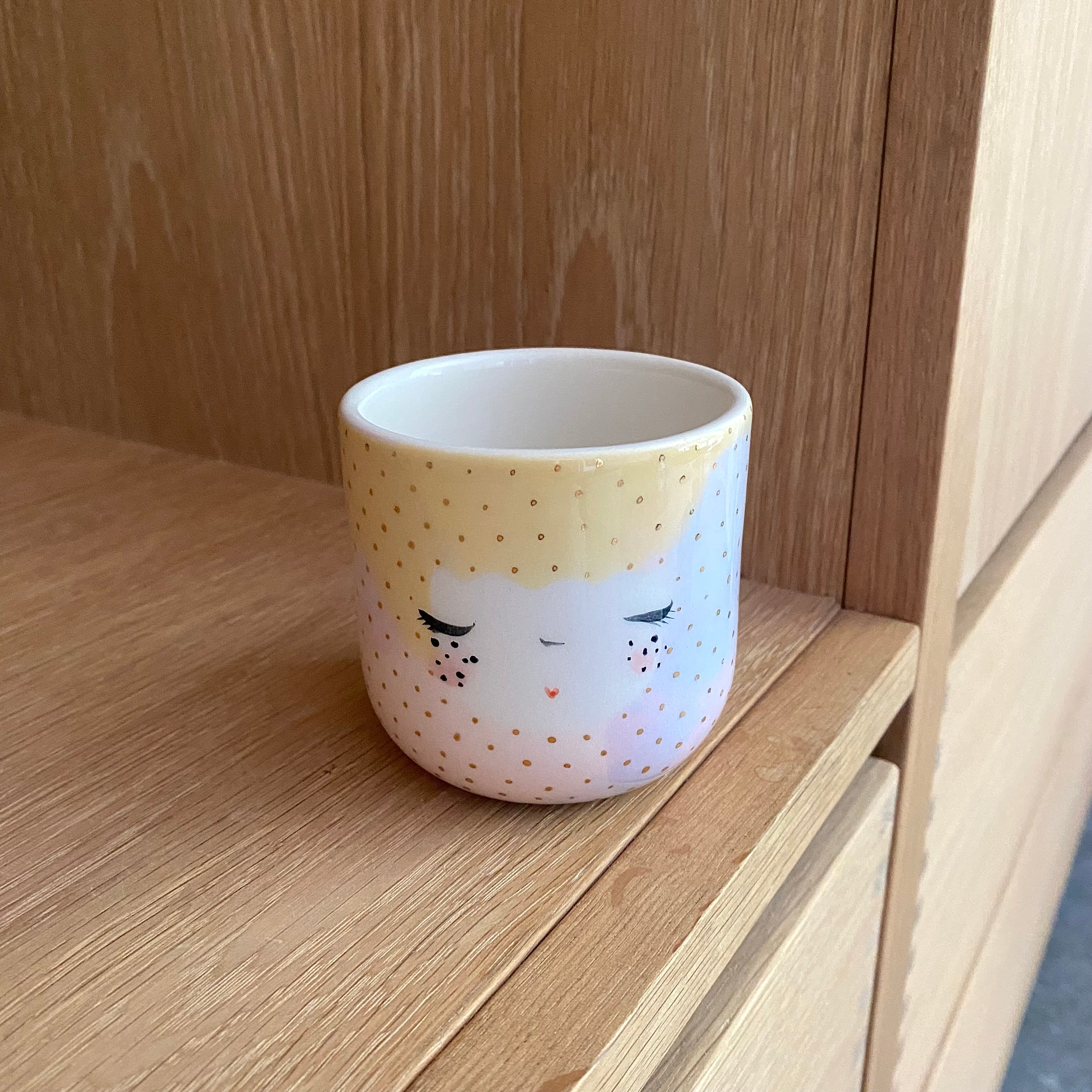 Detalje af håndmalet ansigt og guldprikker på Dots Unicorn koppen