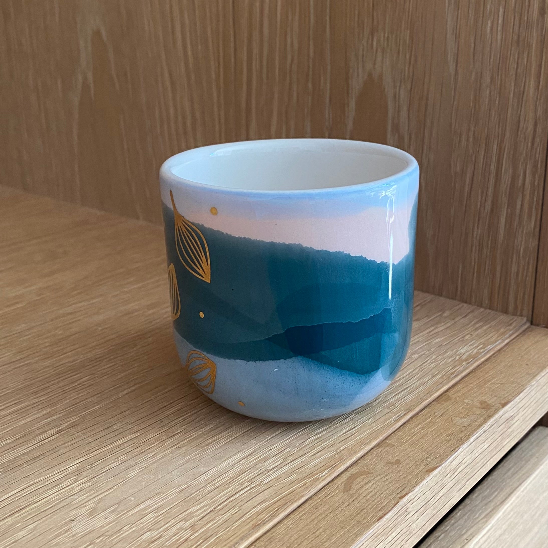 Håndlavet keramik cappuccinokop med guldblade og blå og lyserøde farver på den ene side af koppen – håndlavet fra Marinski