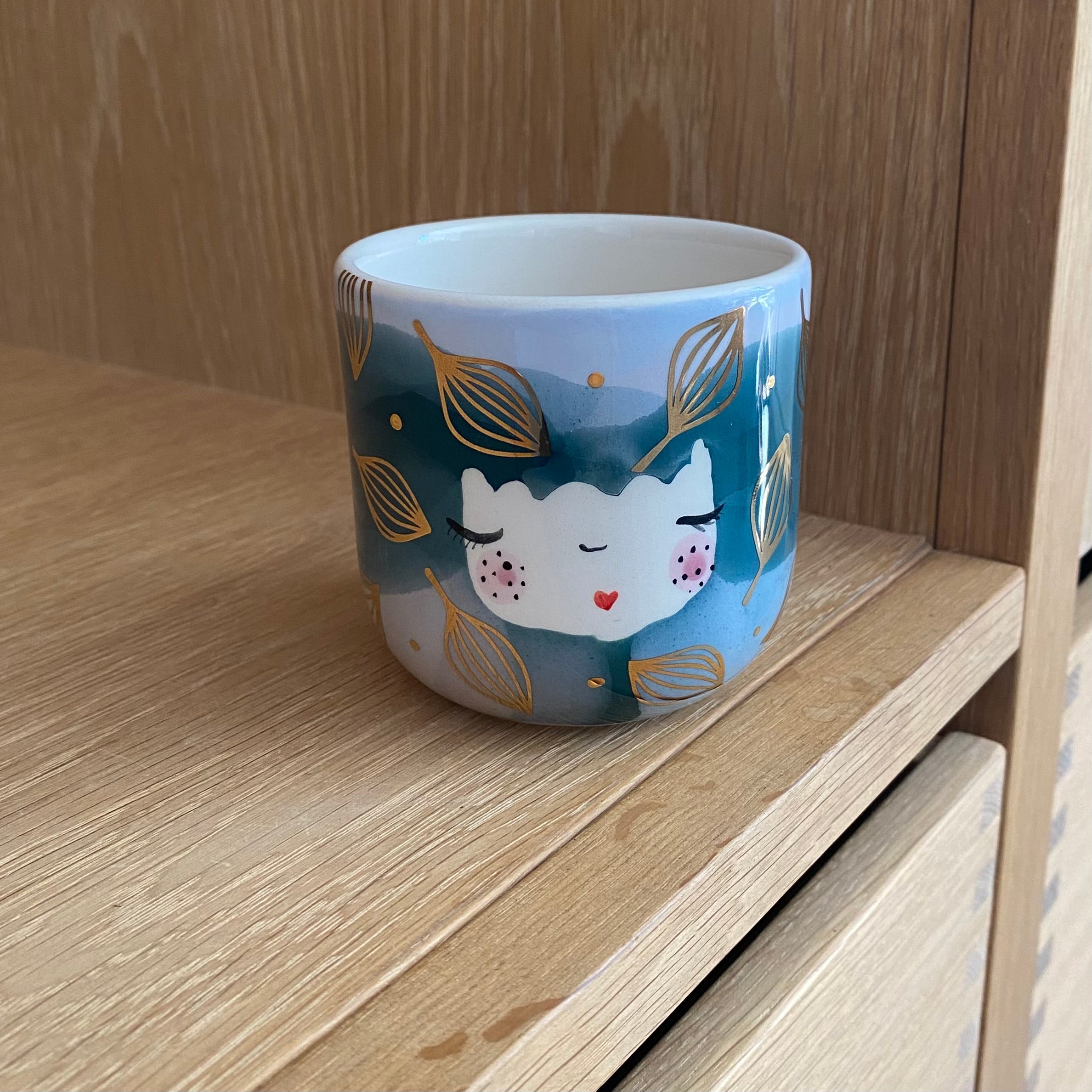 Håndlavet keramik cappuccinokop med guldblade og blå og lyserøde farver på den ene side af koppen – håndlavet fra Marinski Heartmades