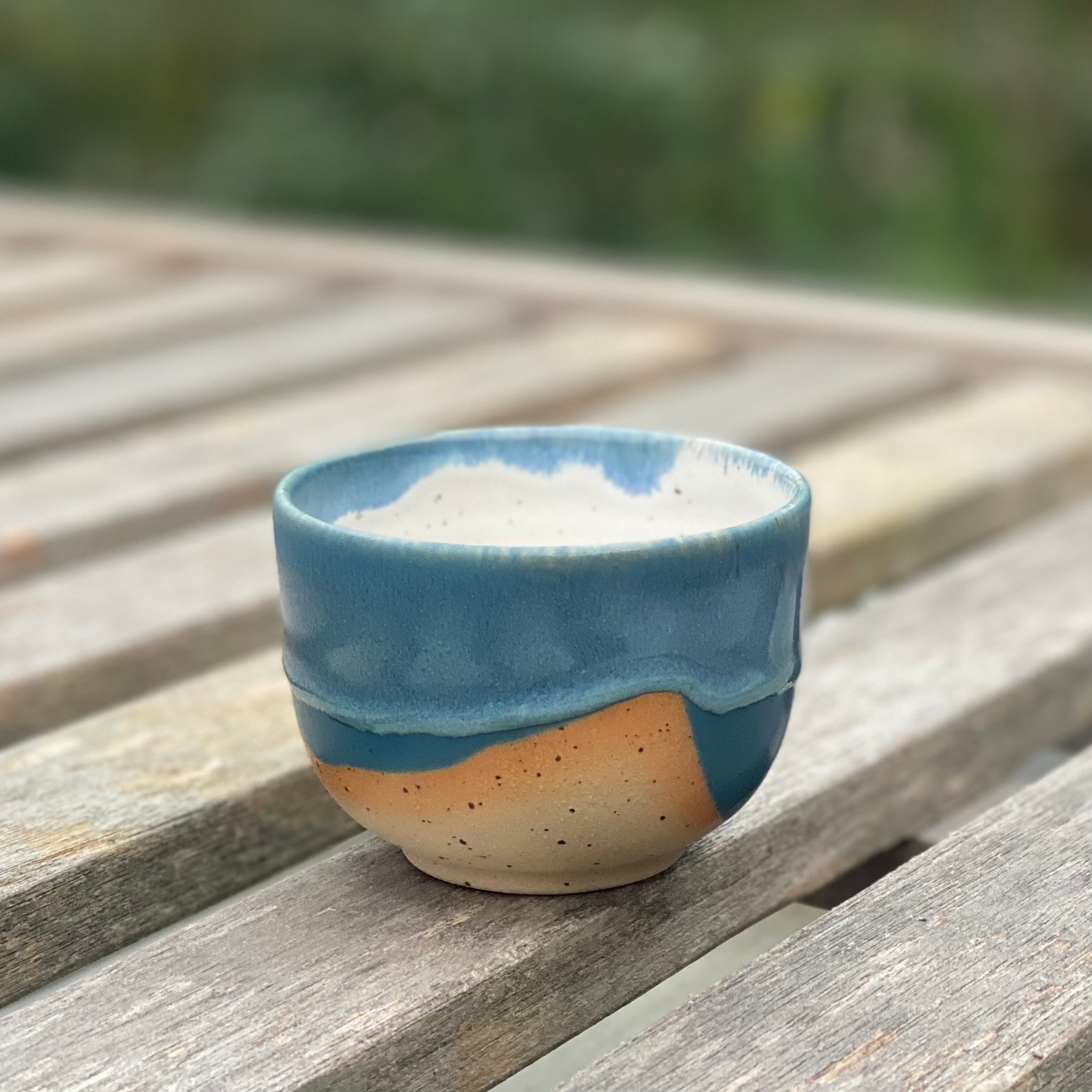 Hånddrejet cappuccinokop fra Marinski Heartmades i rå stentøj og blå glasur – set på bord