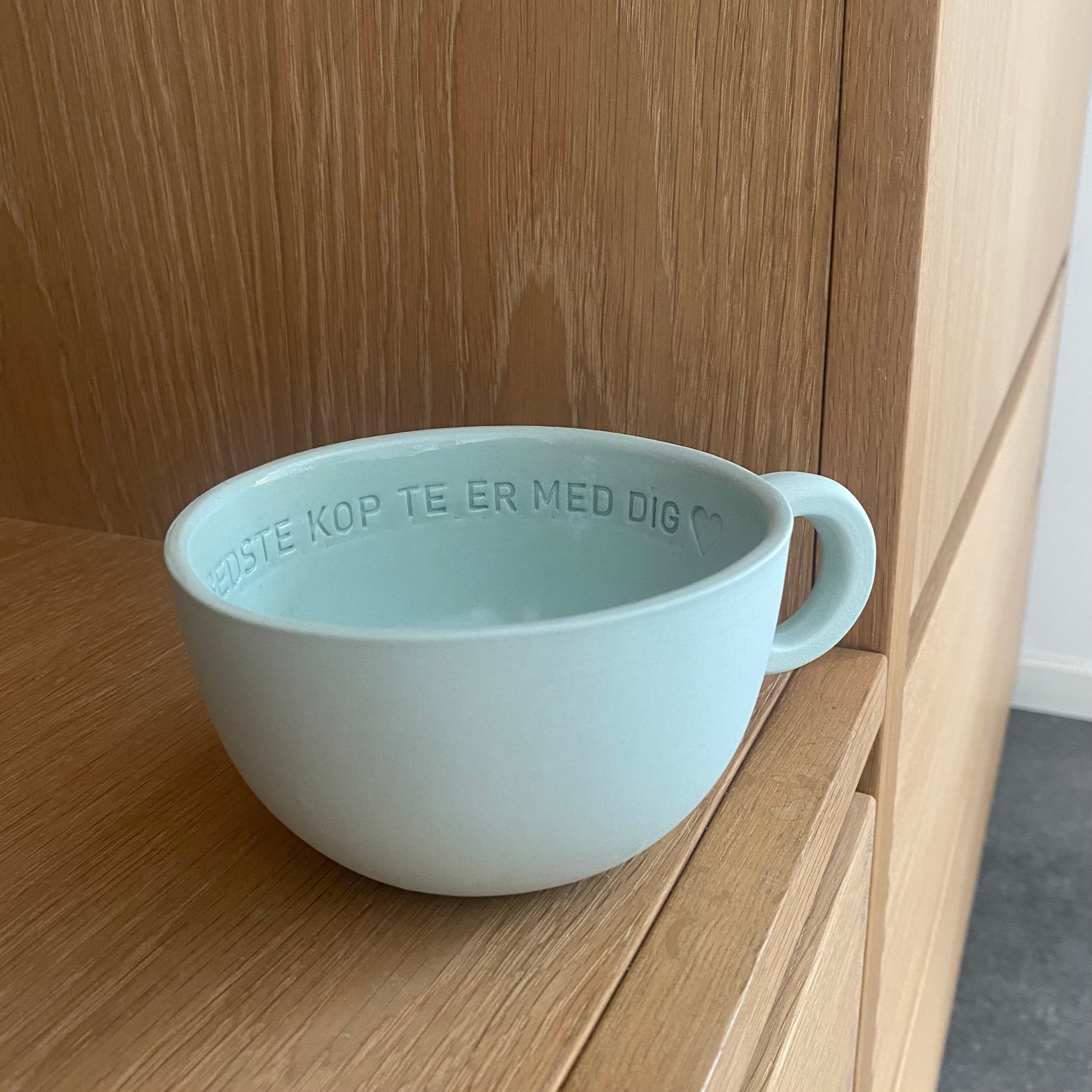 Chubby tekop i mintfarvet håndlavet keramik med teksten “Den bedste kop te er med dig” indeni