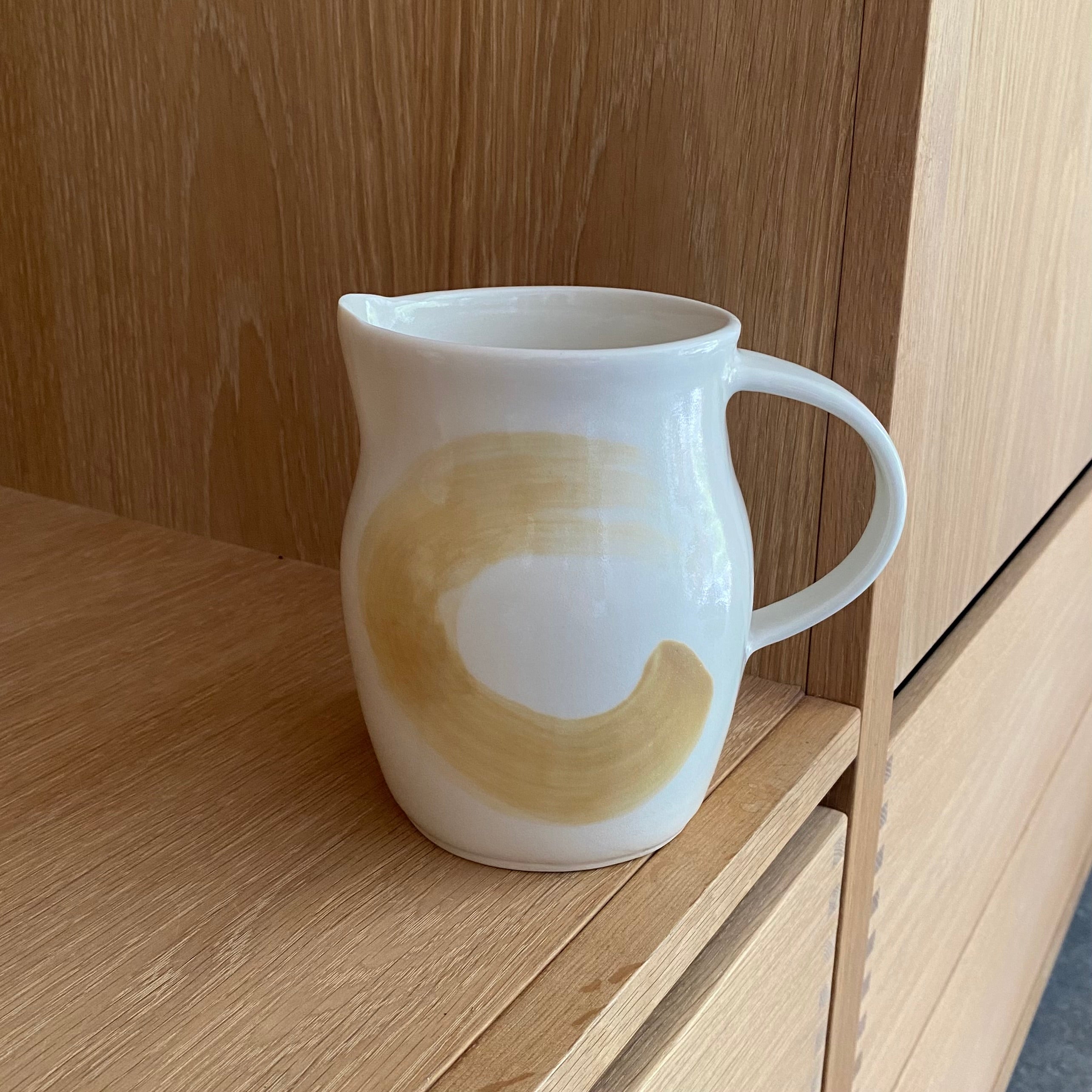 Hånddrejet kande i keramik med gul bølge – porcelænskande designet af Ann-Louise Roman