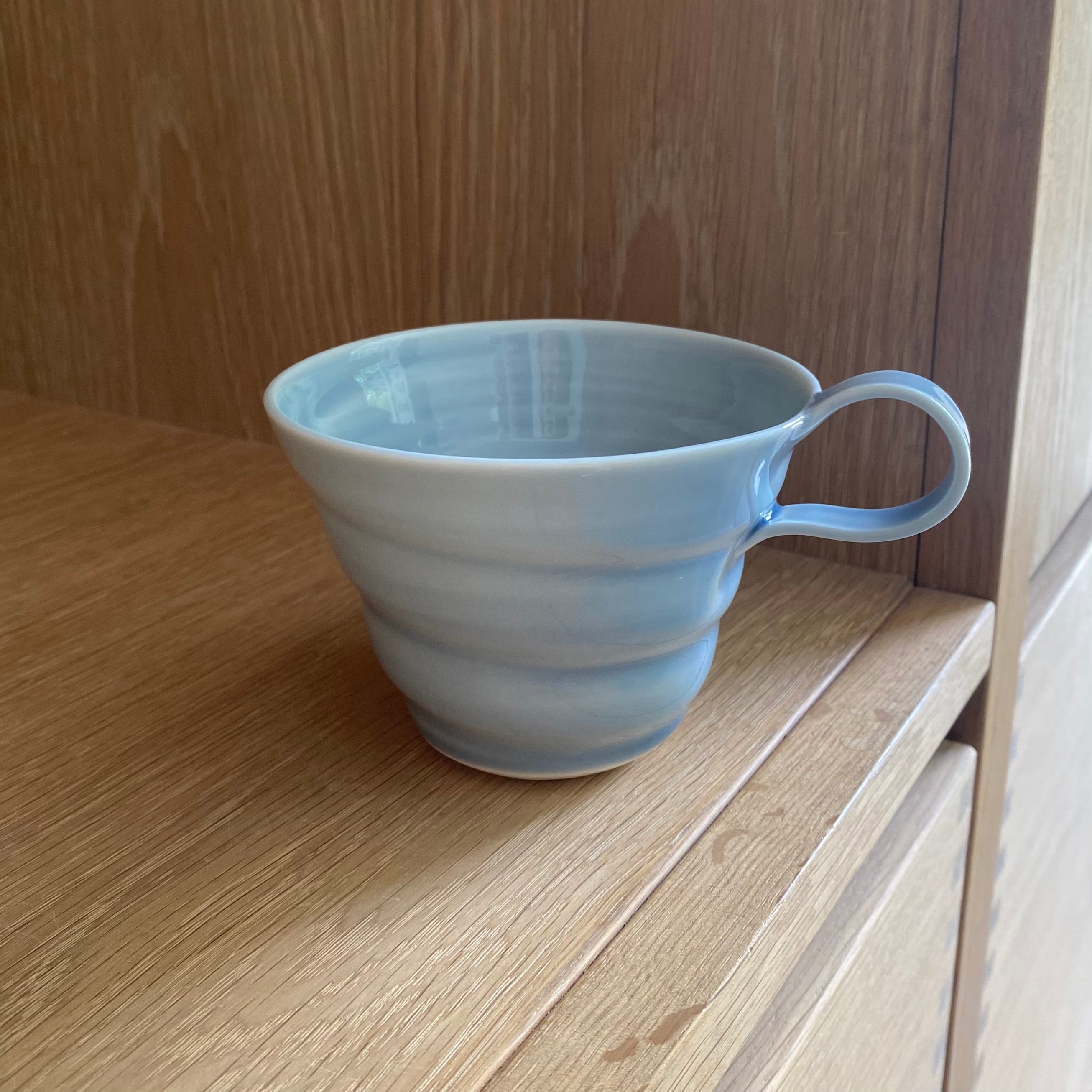 Hånddrejet spiralkop i lys blå porcelæn – eksklusivt design fra Rikke Mangelsen hos unika:k