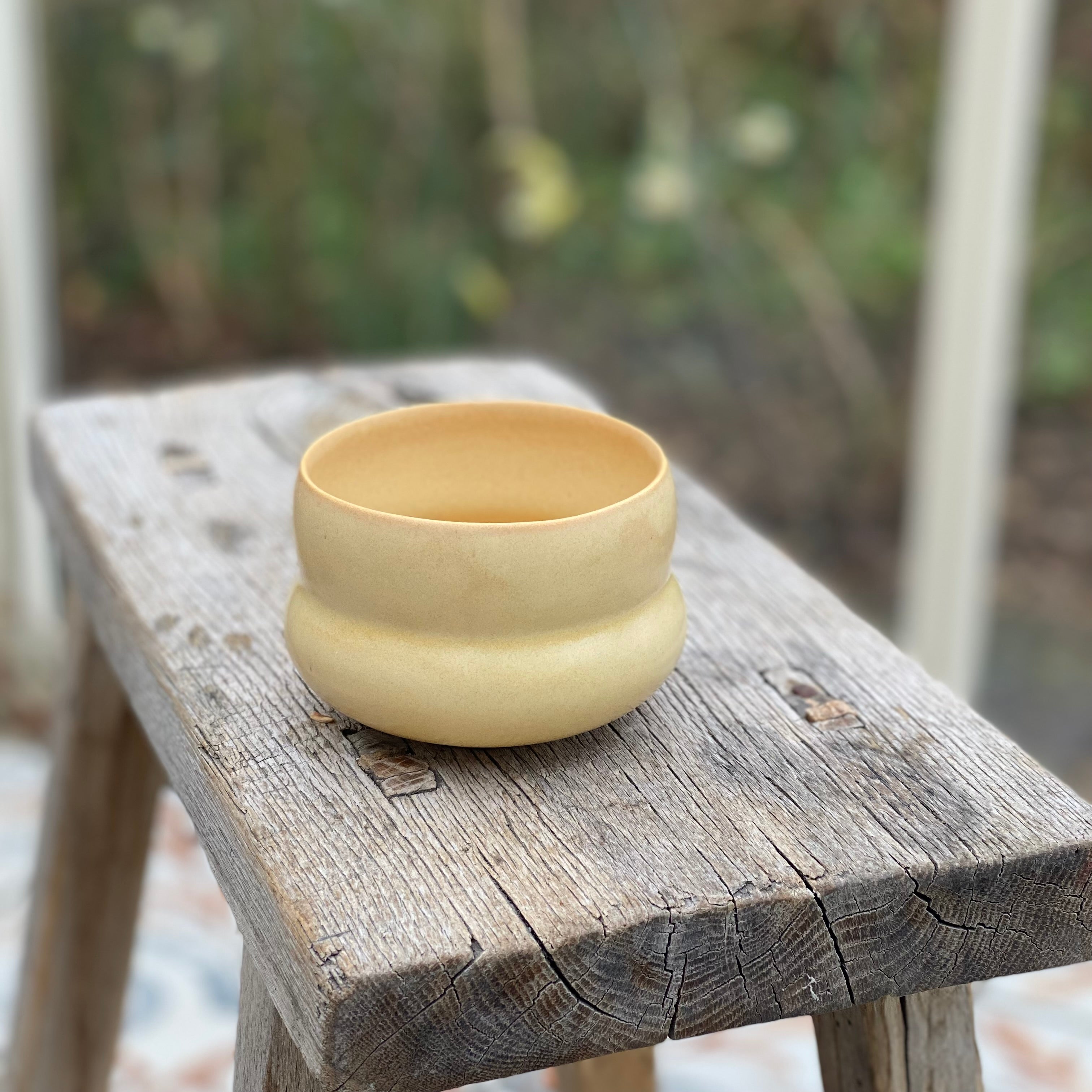 Kaffekop IWA Wheat Yellow fra Oh Oak på træskammel – håndlavet keramik fra Bornholm hos unika:k