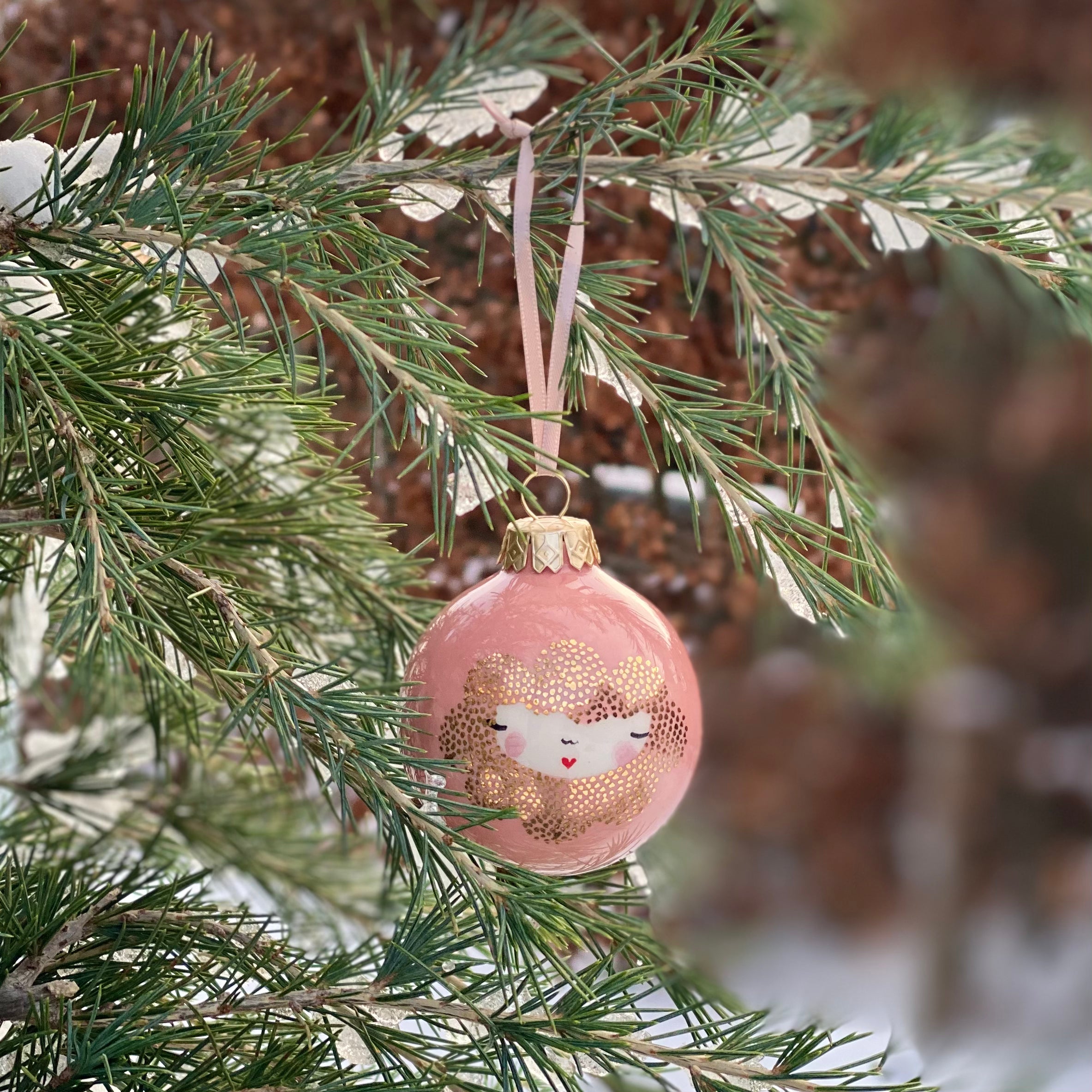 Håndlavet julekugle i peach pink med gulddetaljer og ansigt – hænger på grantræ