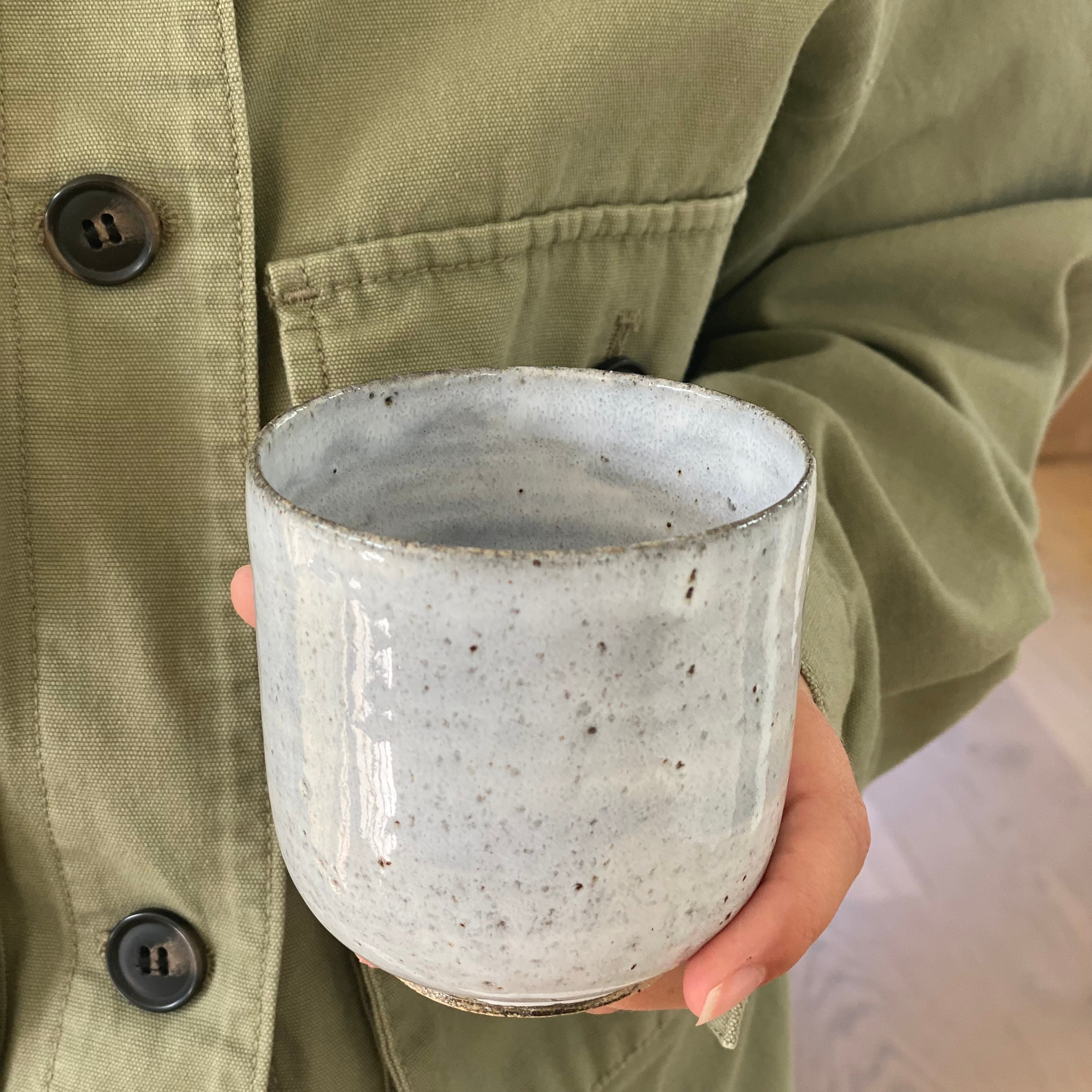 Hånddrejet lyseblå kaffekop holdt i hånden – dansk keramik af Tasja P