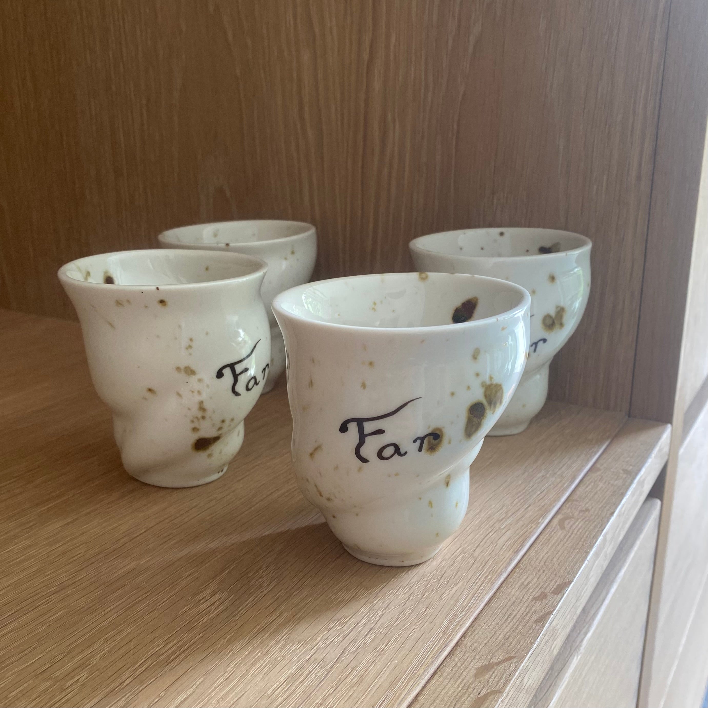 Keramikkoppen “Far” fra Studio Aarhus placeret på kophylde med lignende kopper