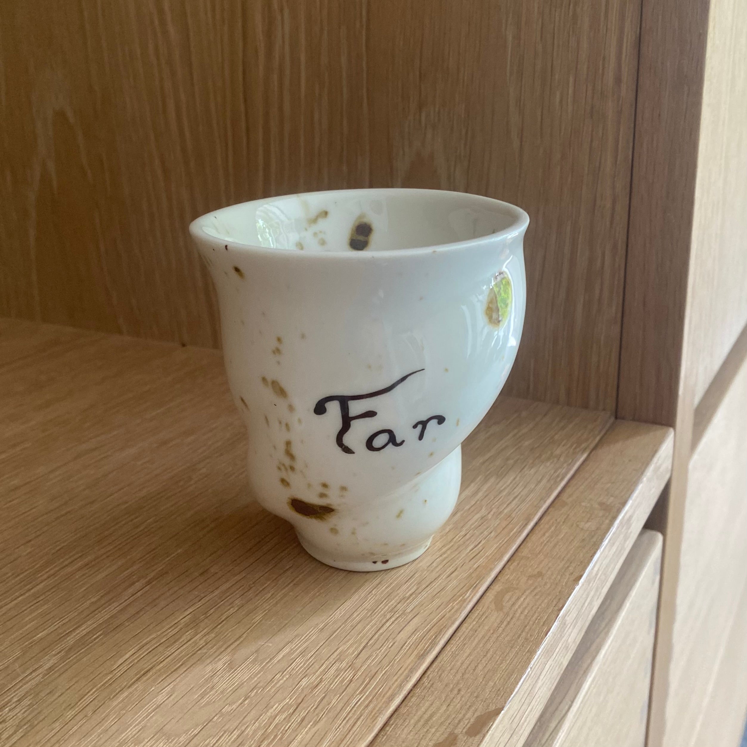 Håndlavet keramikkop med FAR-tekst fra Studio Aarhus – stående på træbord