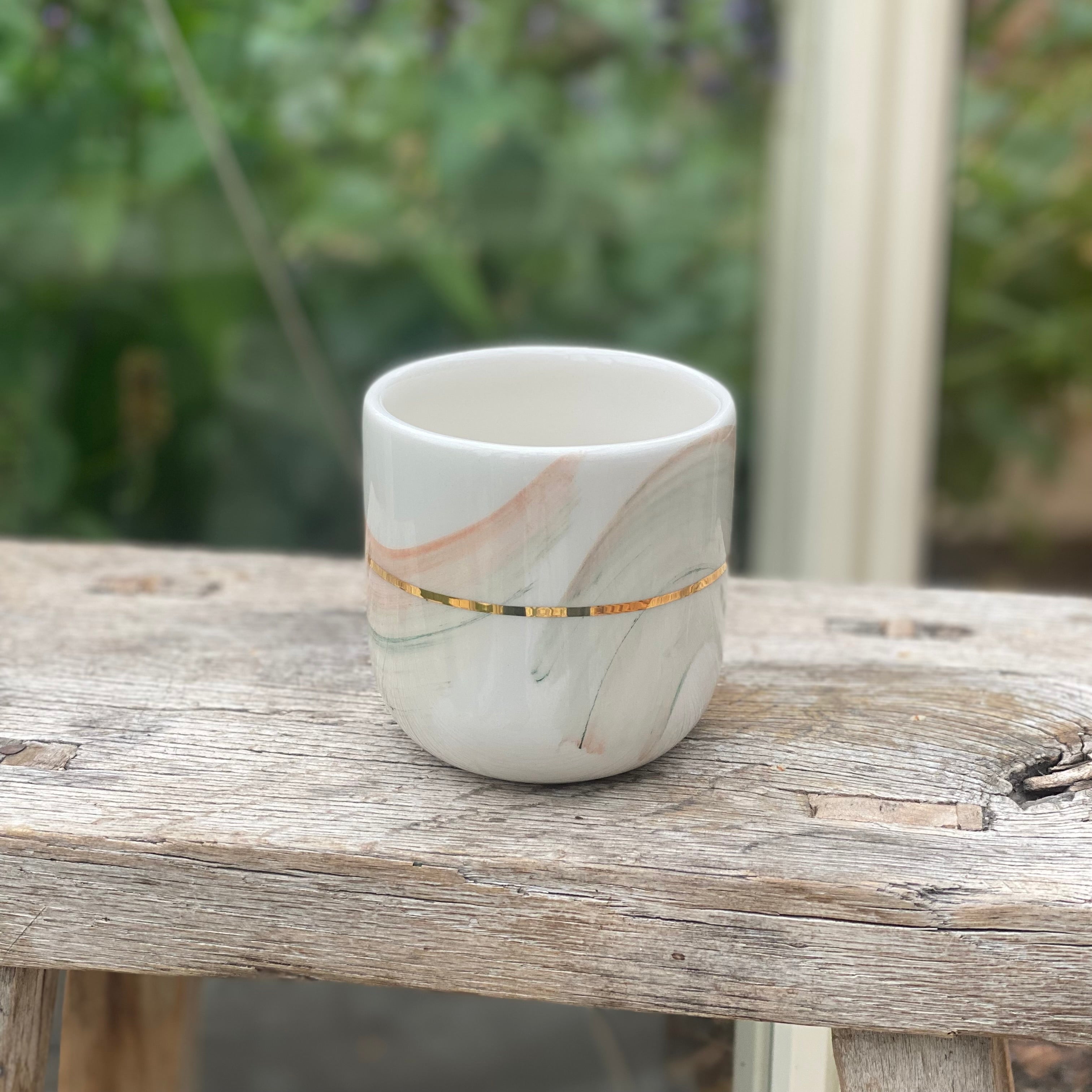 Håndlavet latte kop med penselstrøg og gulddetaljer – kreativ keramik i mint og coral