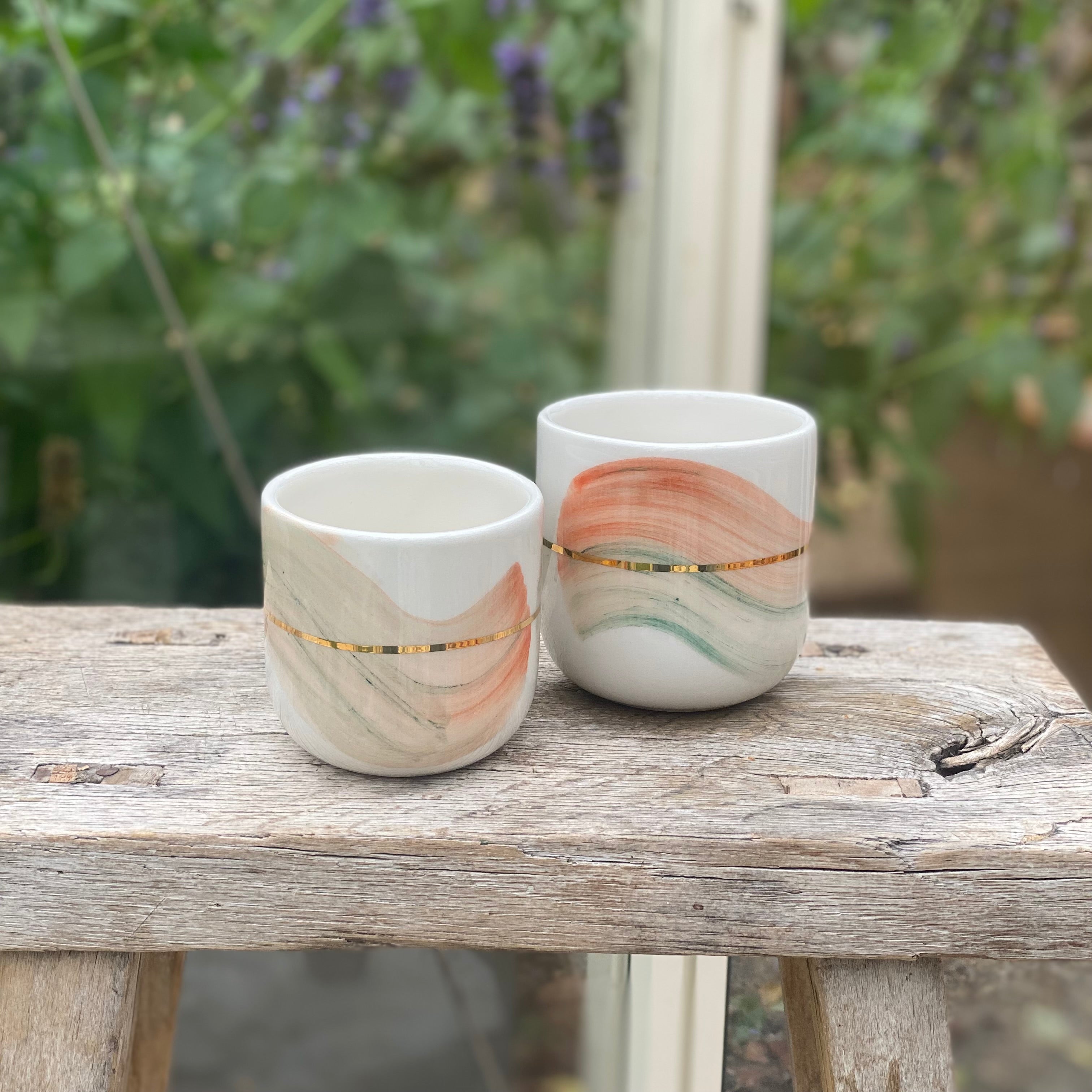 Keramikkop i latte-størrelse med unikt penselstrøg-design i mint og coral