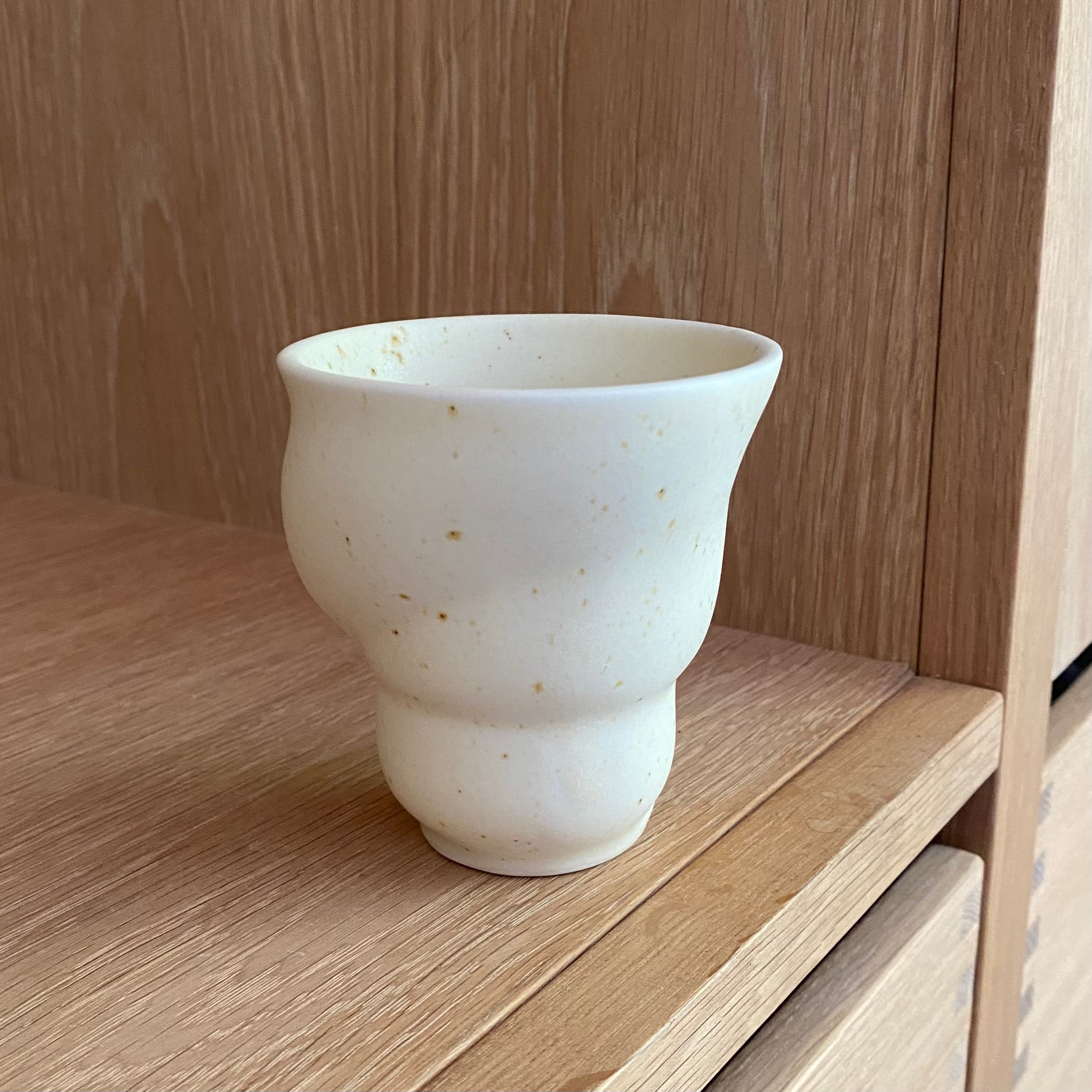 Håndlavet keramikkop “Skal” fra Studio Aarhus – stående på bord med naturligt lys