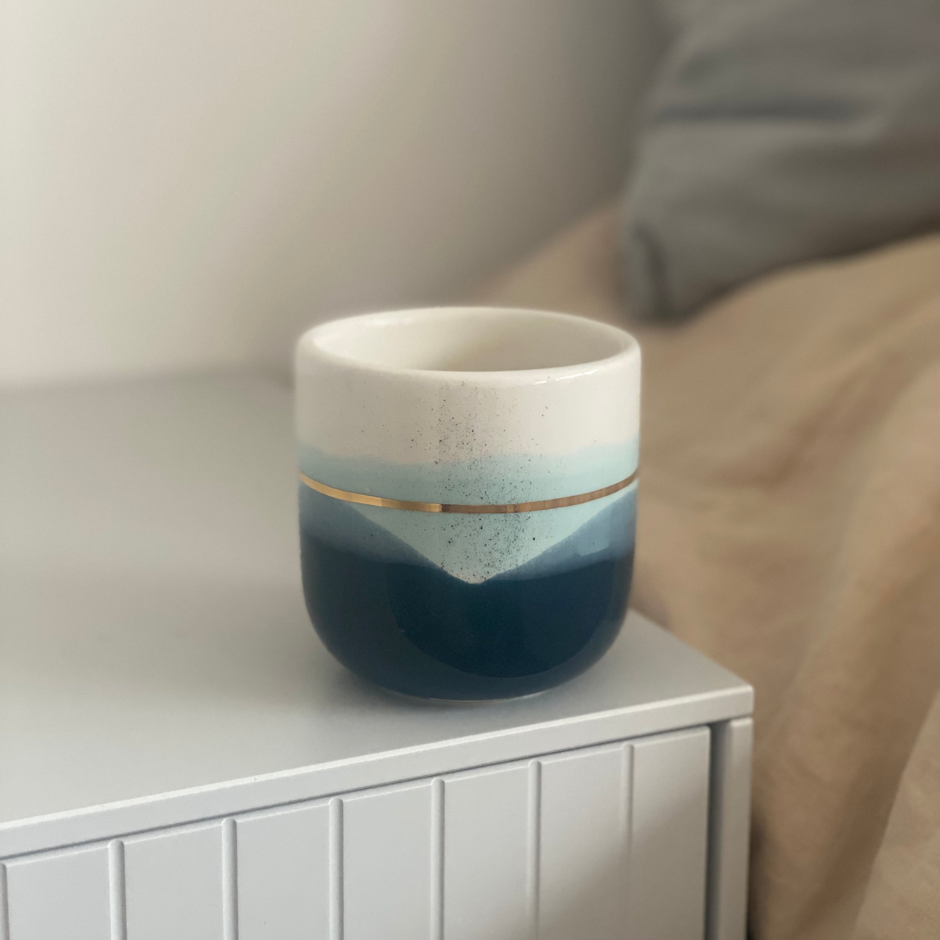 Håndlavet keramikkop fra Marinski med mørkeblå og mint glasur samt gulddetalje – “Landscape”-design