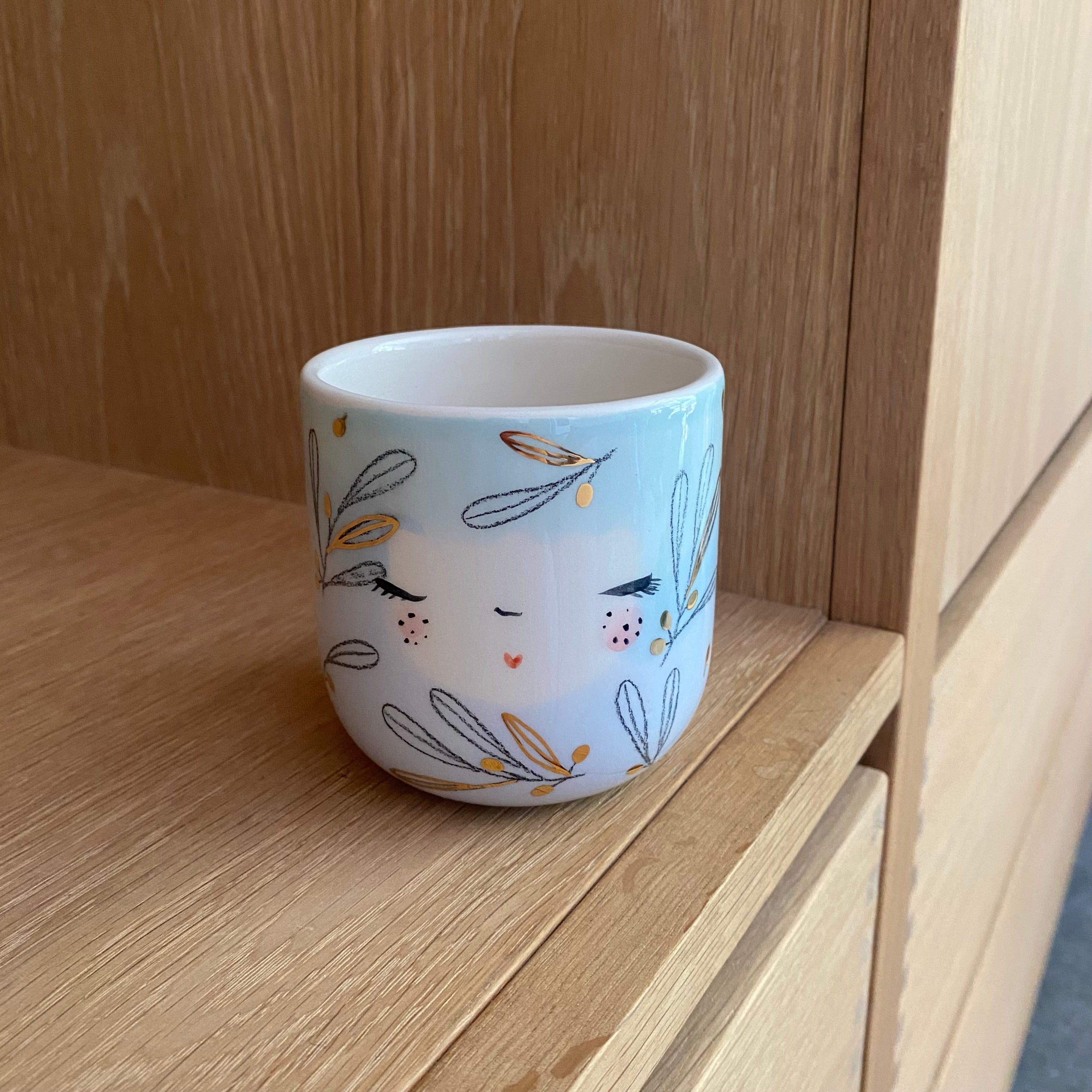 Håndlavet keramik lattekop "Olives" fra Marinski med lyseblå og lysegrønne pasteller og guldillustration