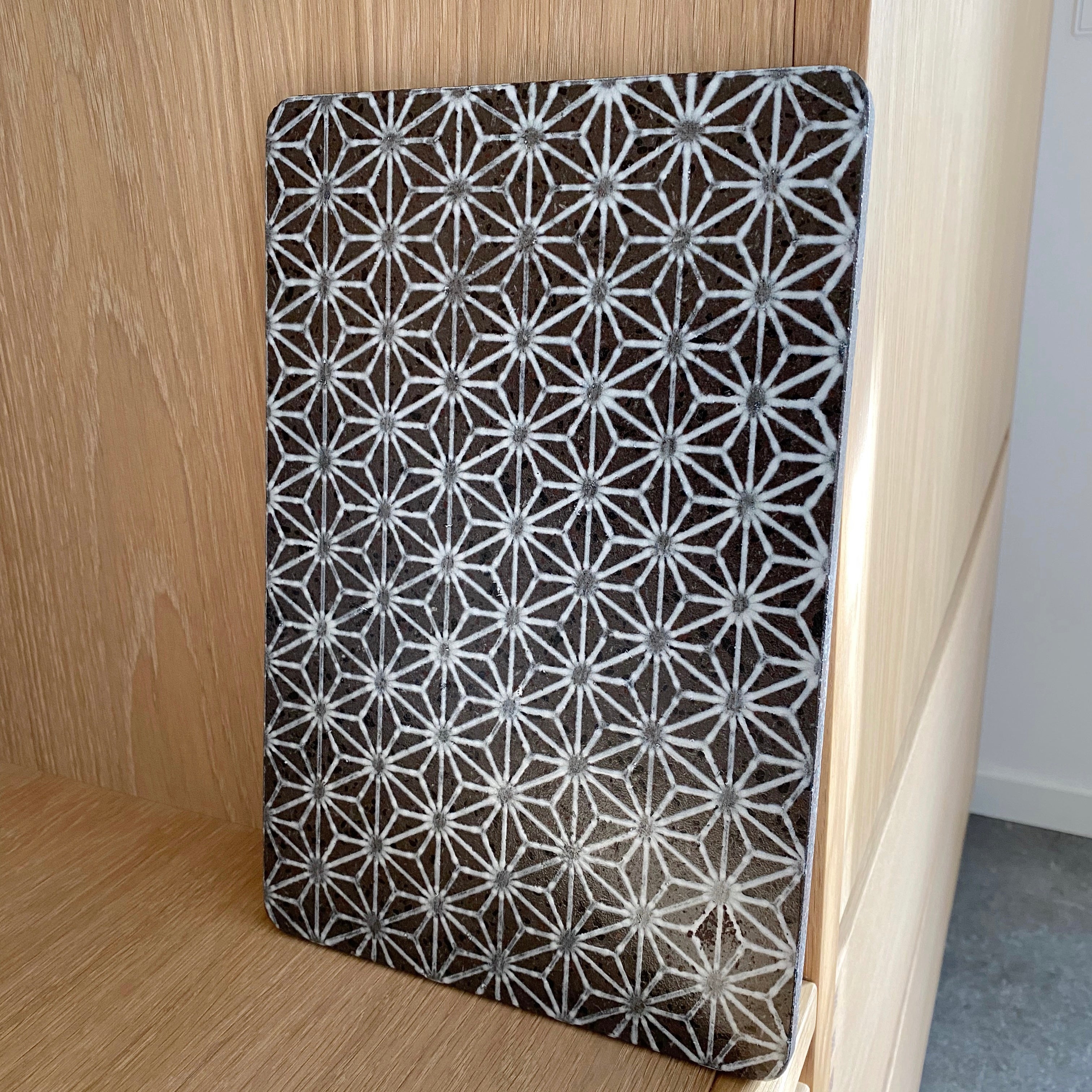 Håndlavet lavastensbræt i mørk lavasten med hvidt stjernemønster fra Made a Mano