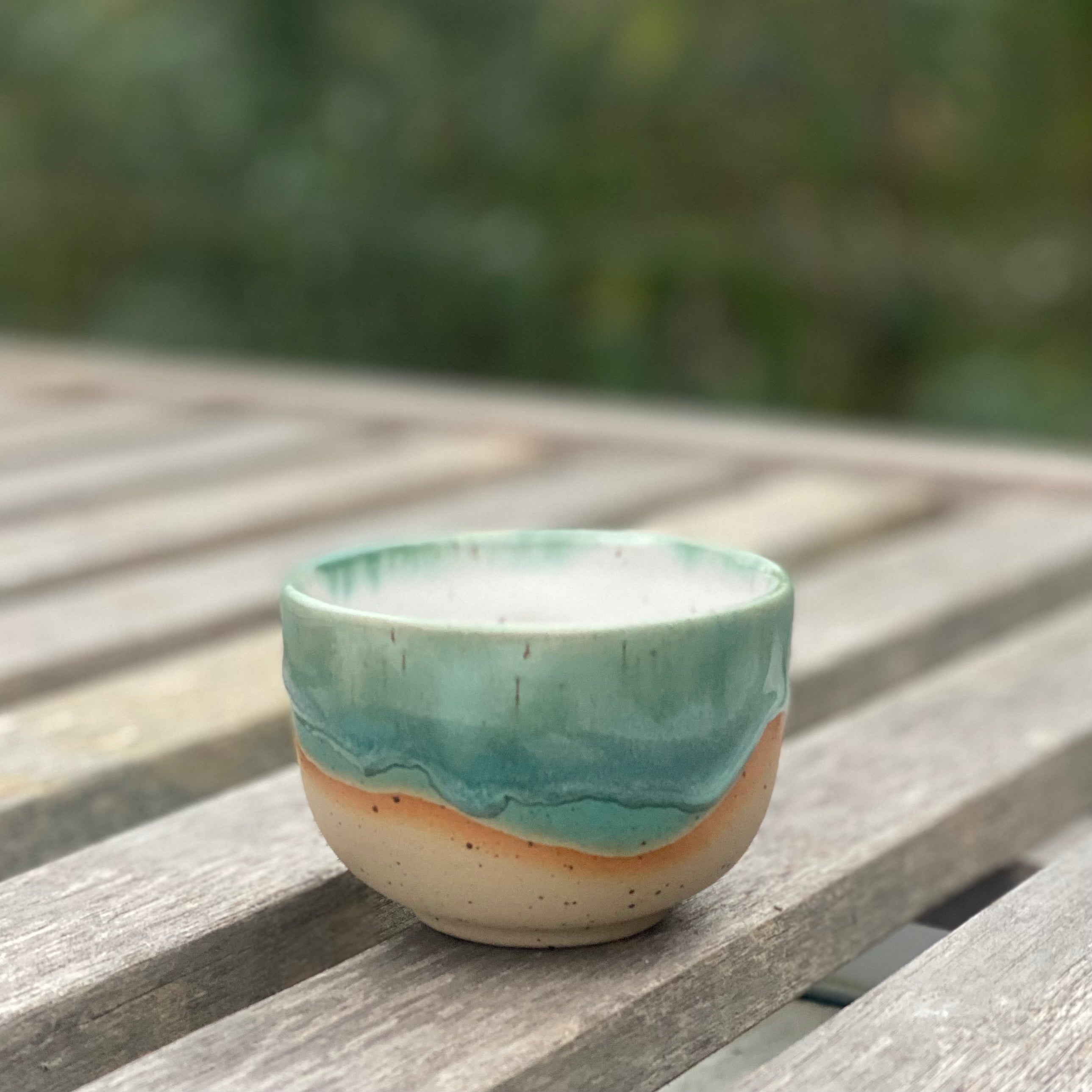 Hånddrejet cappuccinokop fra Marinski Heartmades i grøn glasur og naturfarvet stentøj – set på bord