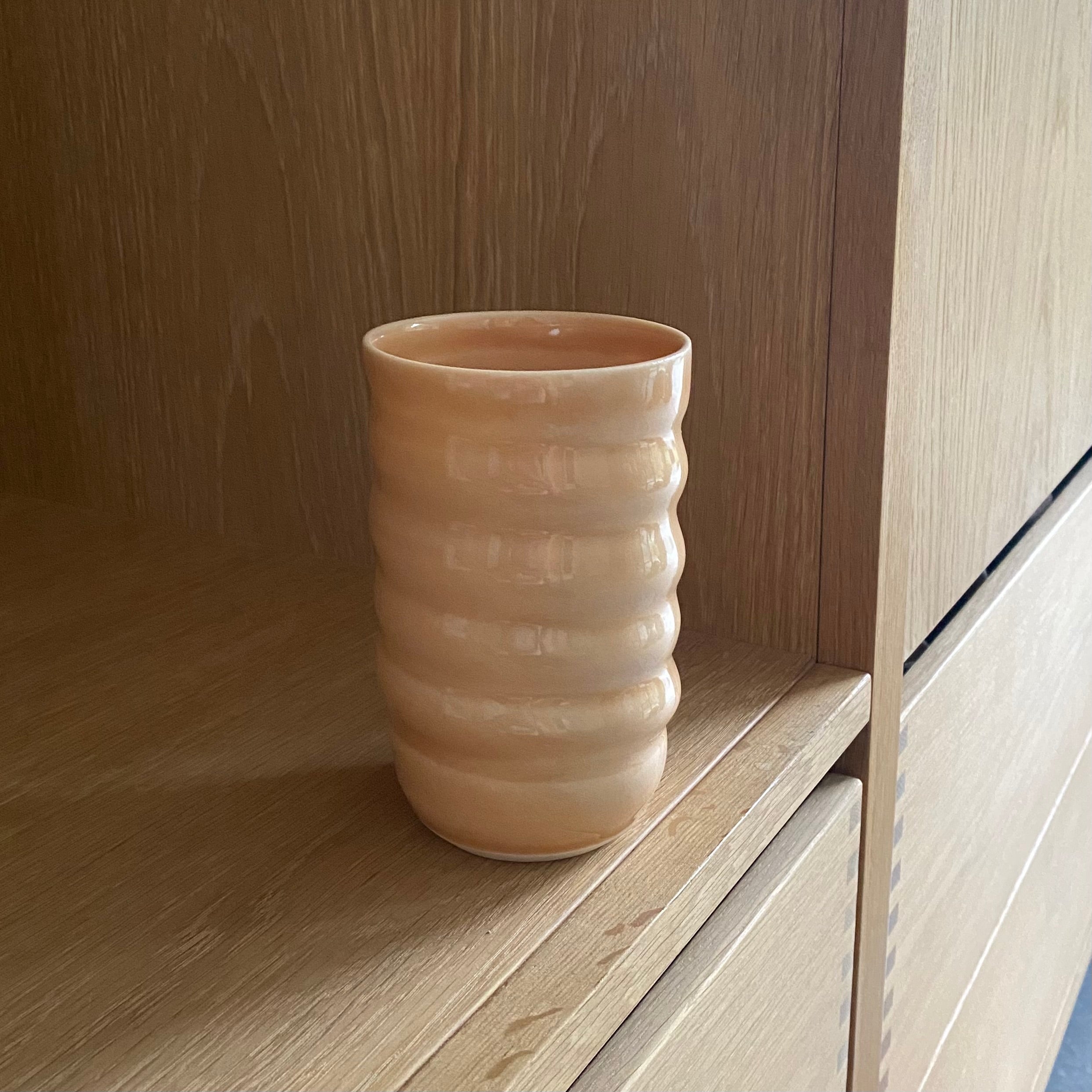 Hånddrejet porcelæn spiralvase i melonfarve – dansk keramik fra Rikke Mangelsen