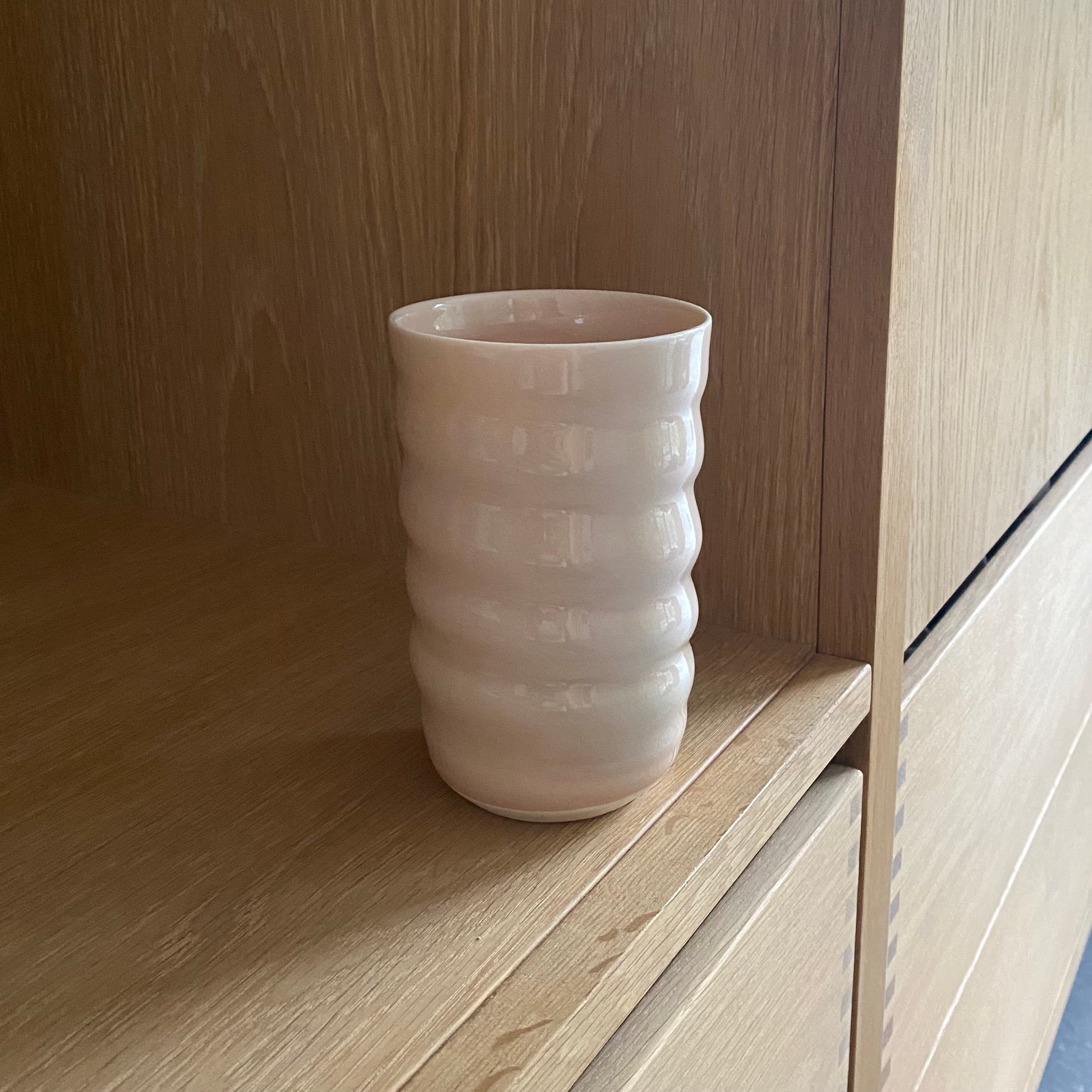 Porcelæn spiralvase i pudder fra Rikke Mangelsen – håndlavet dansk keramik set på bord uden blomster