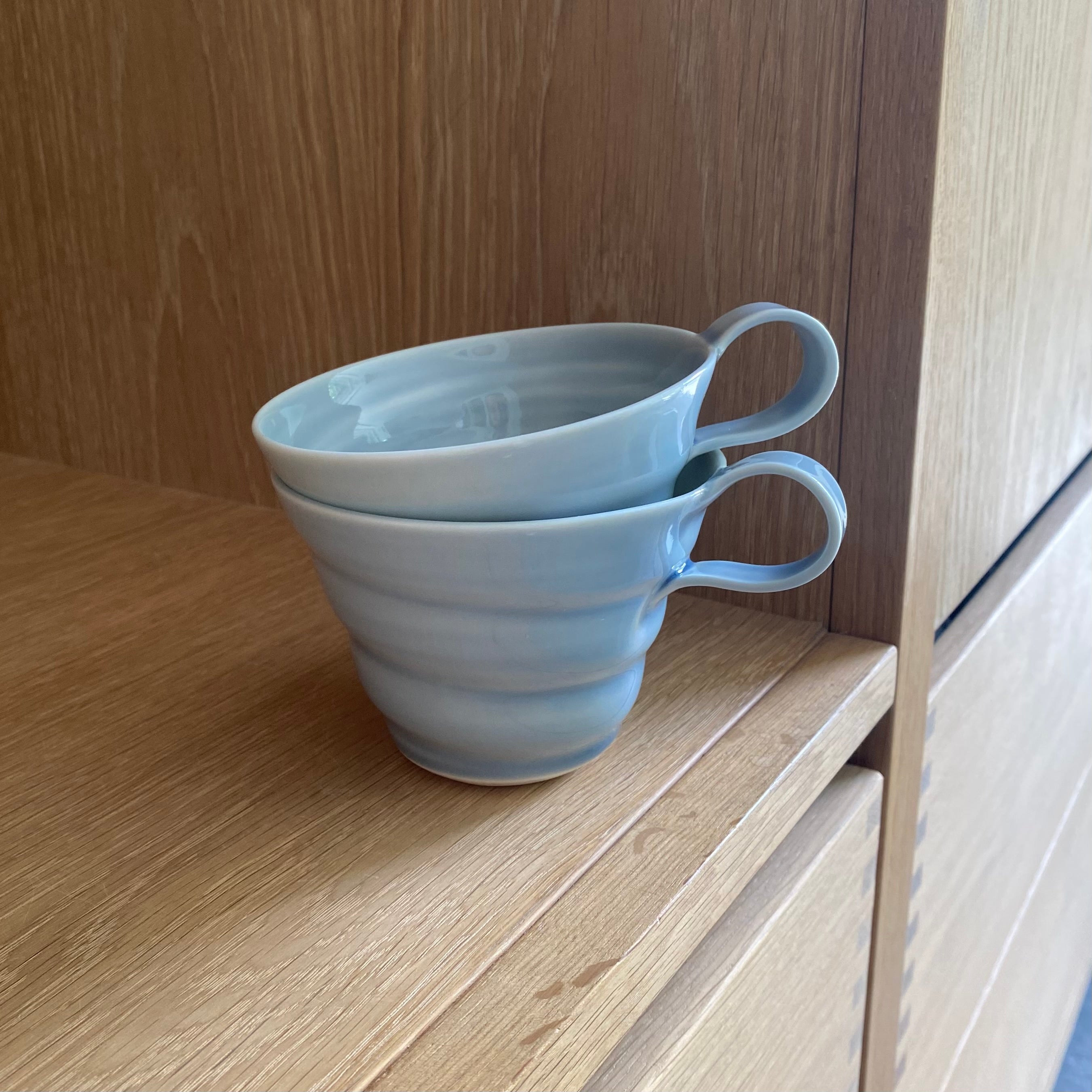 Porcelænskop med hank i lys blå – hånddrejet spiralkop fra Rikke Mangelsen, forhandler unika:k.