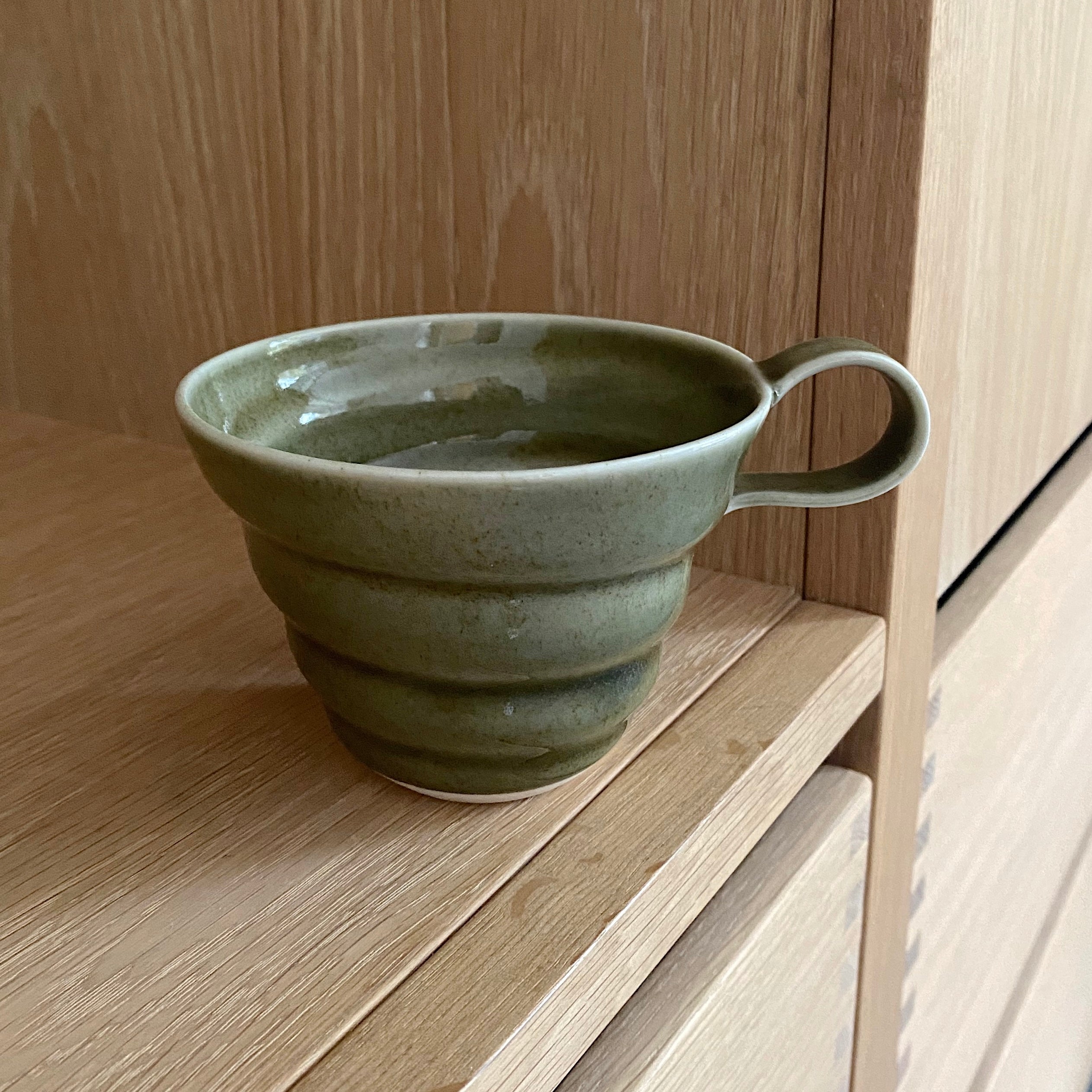 Mosgrøn porcelænskop med spiralriller og hank – hånddrejet af Rikke Mangelsen, unika:k.