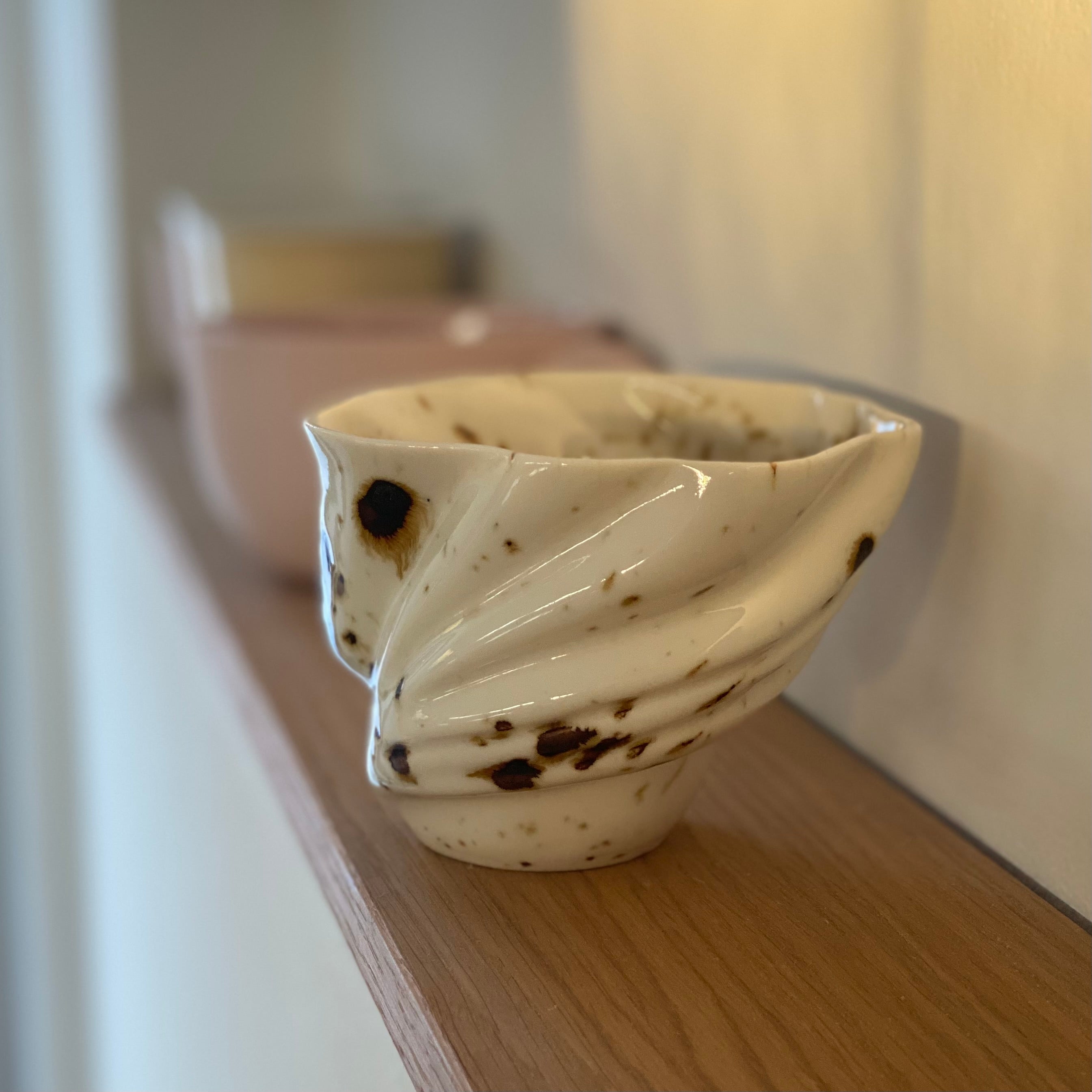 Sidebillede af svanekop med detaljeret riflet overflade og naturinspireret glasur