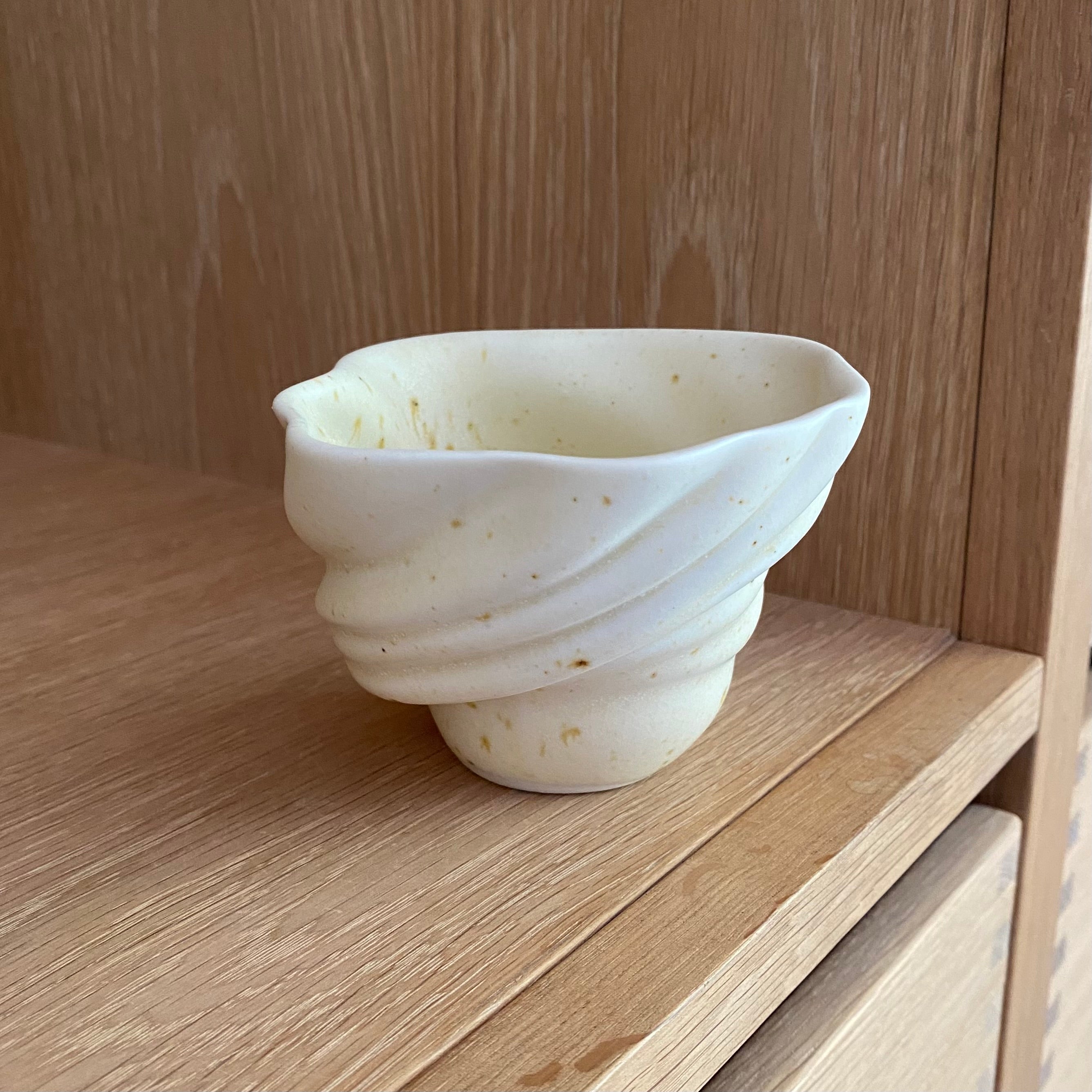 Håndlavet svanekop ‘Skal’ i cremehvid porcelæn – set forfra på bord