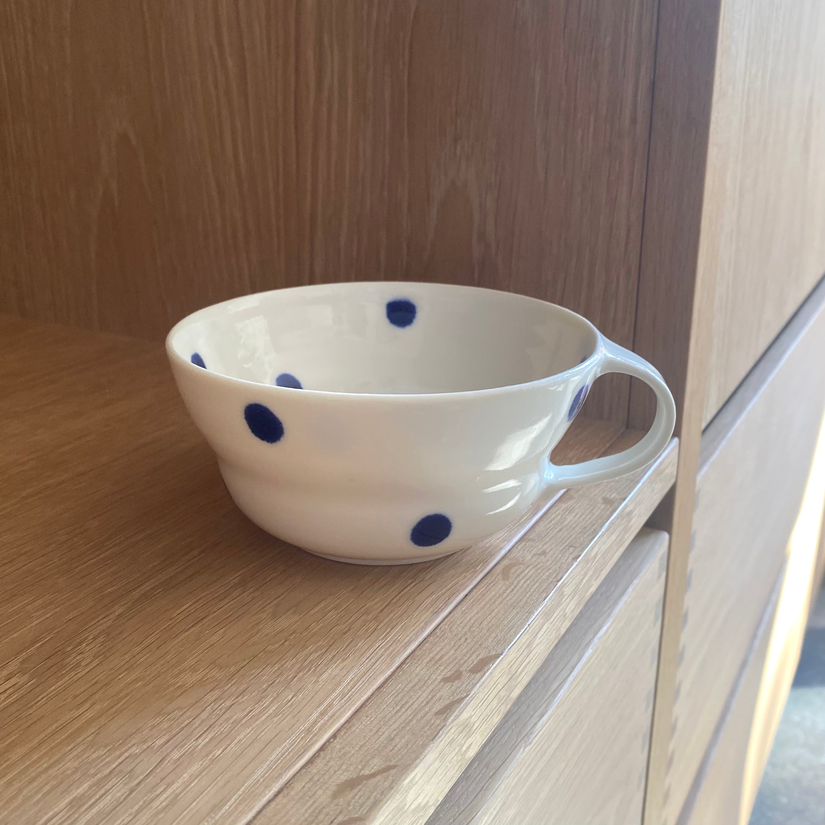 Hånddrejet porcelænskop med store blå prikker, designet af Ann-Louise Roman