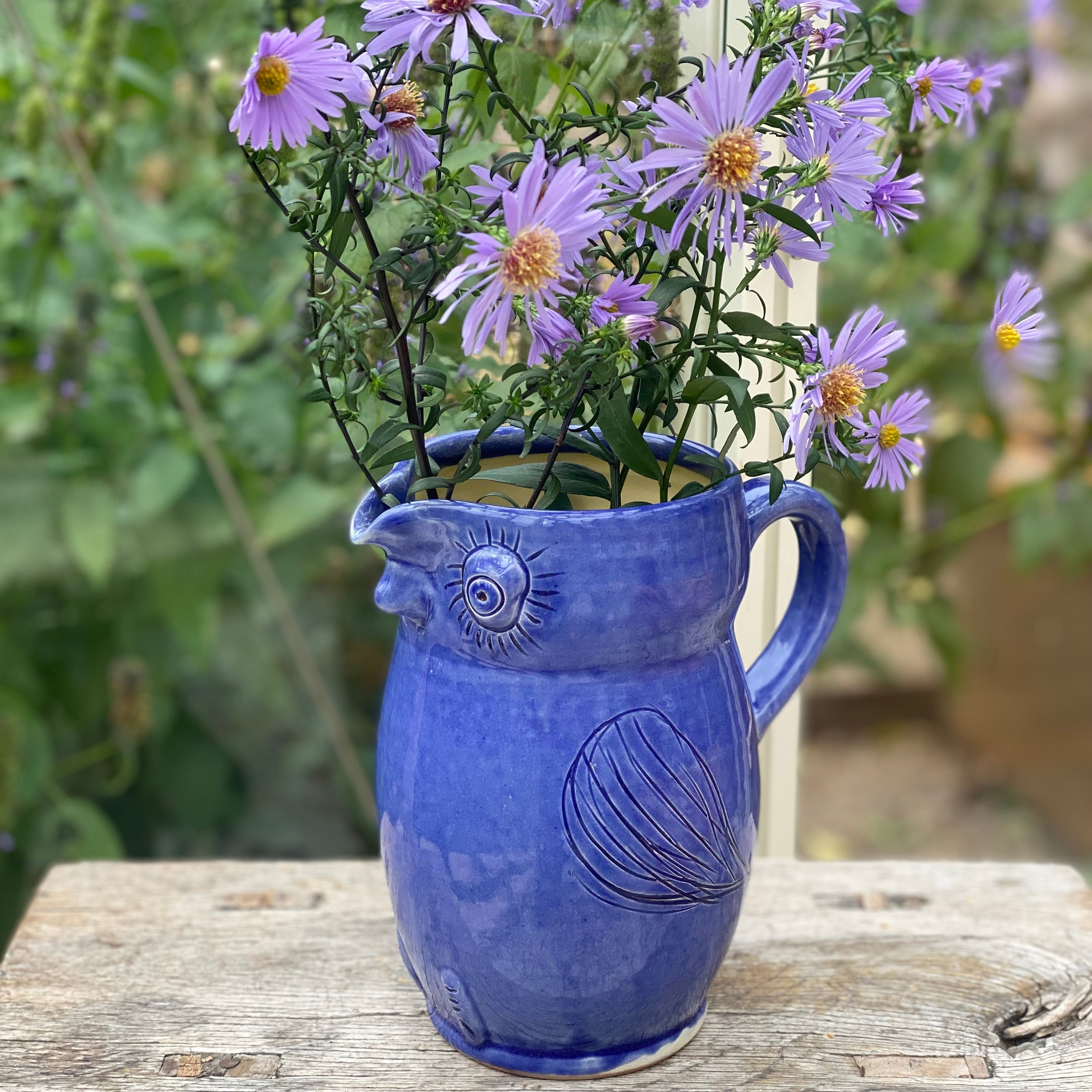 Blå uglekande brugt som vase med en buket lilla asters – håndlavet dansk keramik fra unika:k