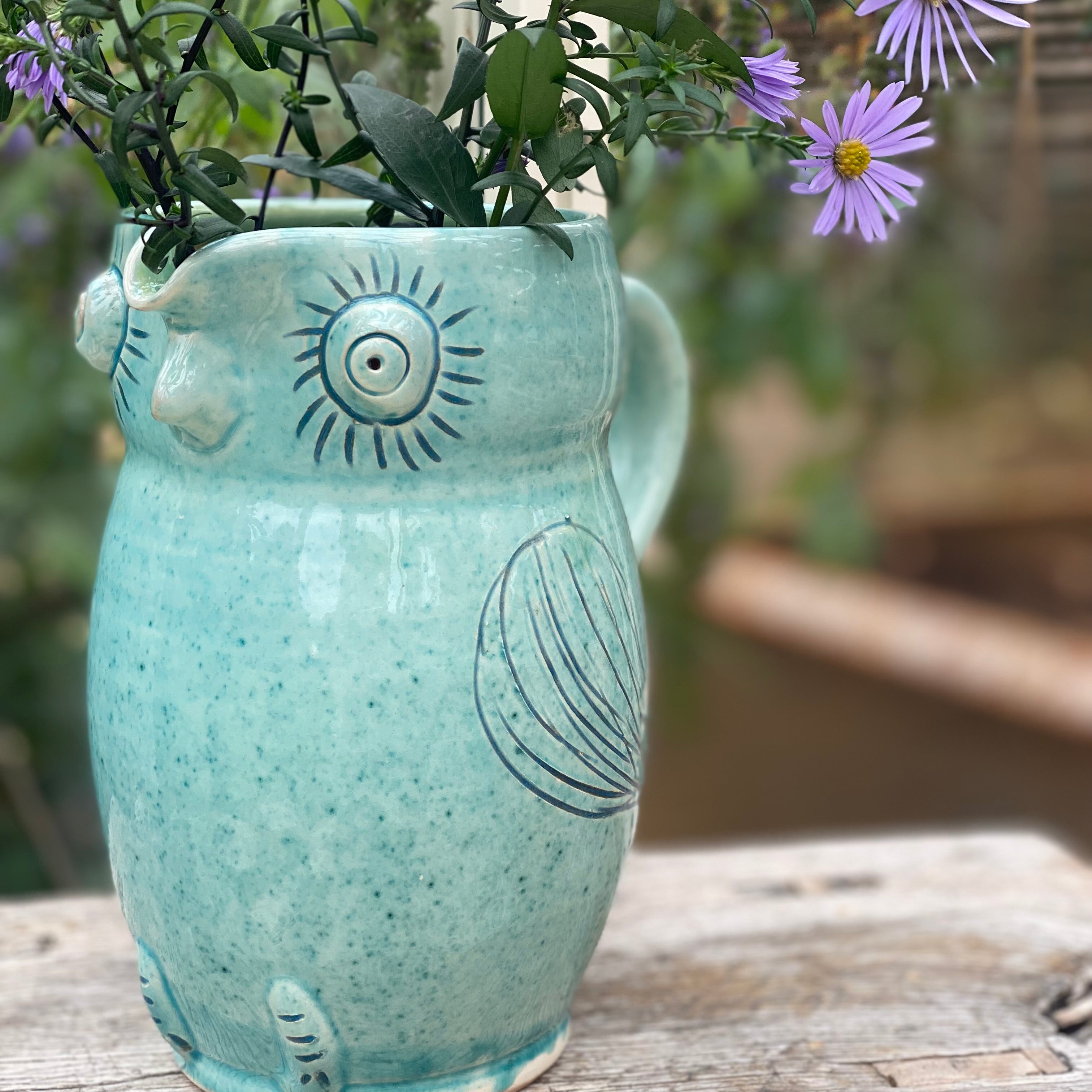Turkis uglekande fra Erik Bendtsen brugt som vase med en buket asters – håndlavet dansk keramik