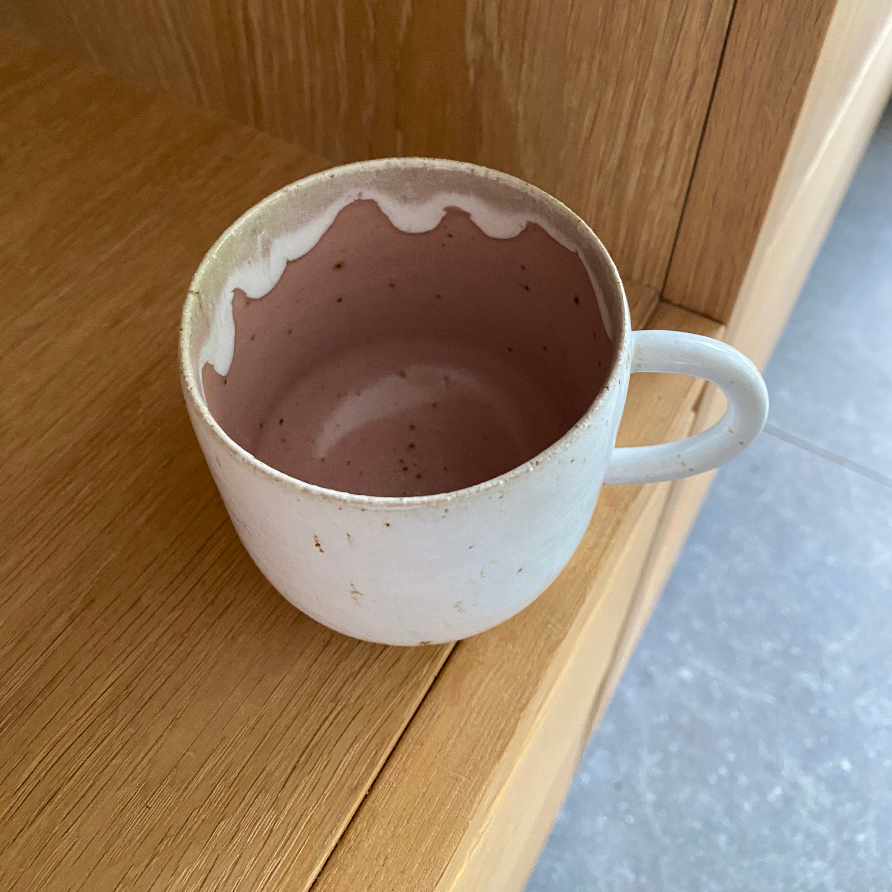 Kaffekop med hank i lyserød keramik set oppefra – hånddrejet dansk keramik med lyserød glasur indeni