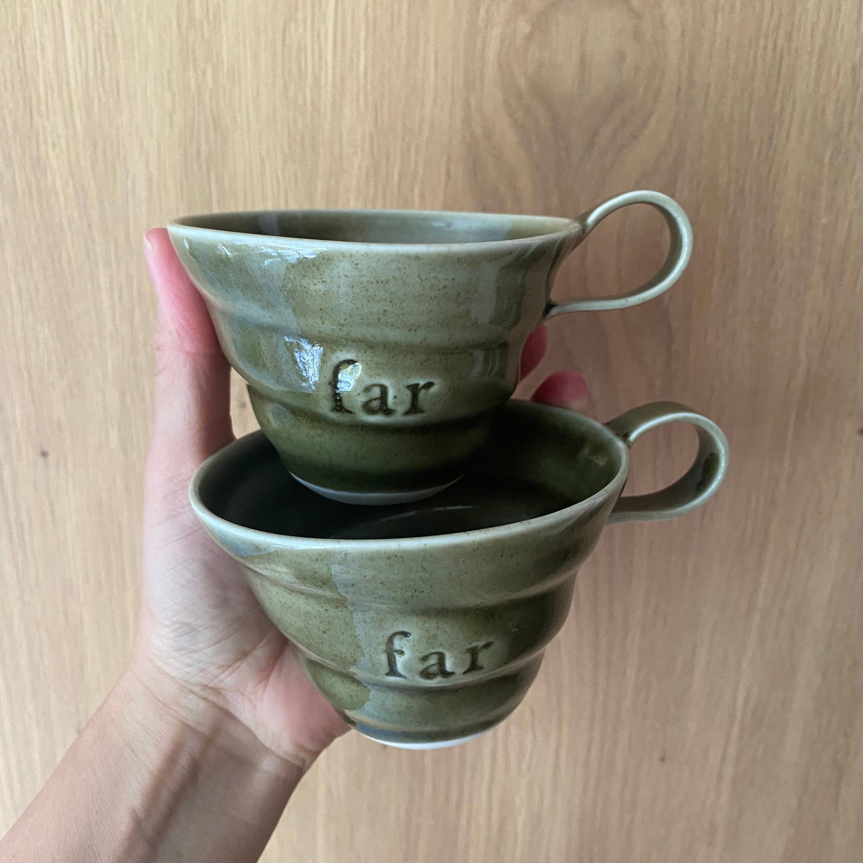 To grønne far kopper holdt i hånden – hånddrejet navnekop i porcelæn fra Rikke Mangelsen hos Unika K