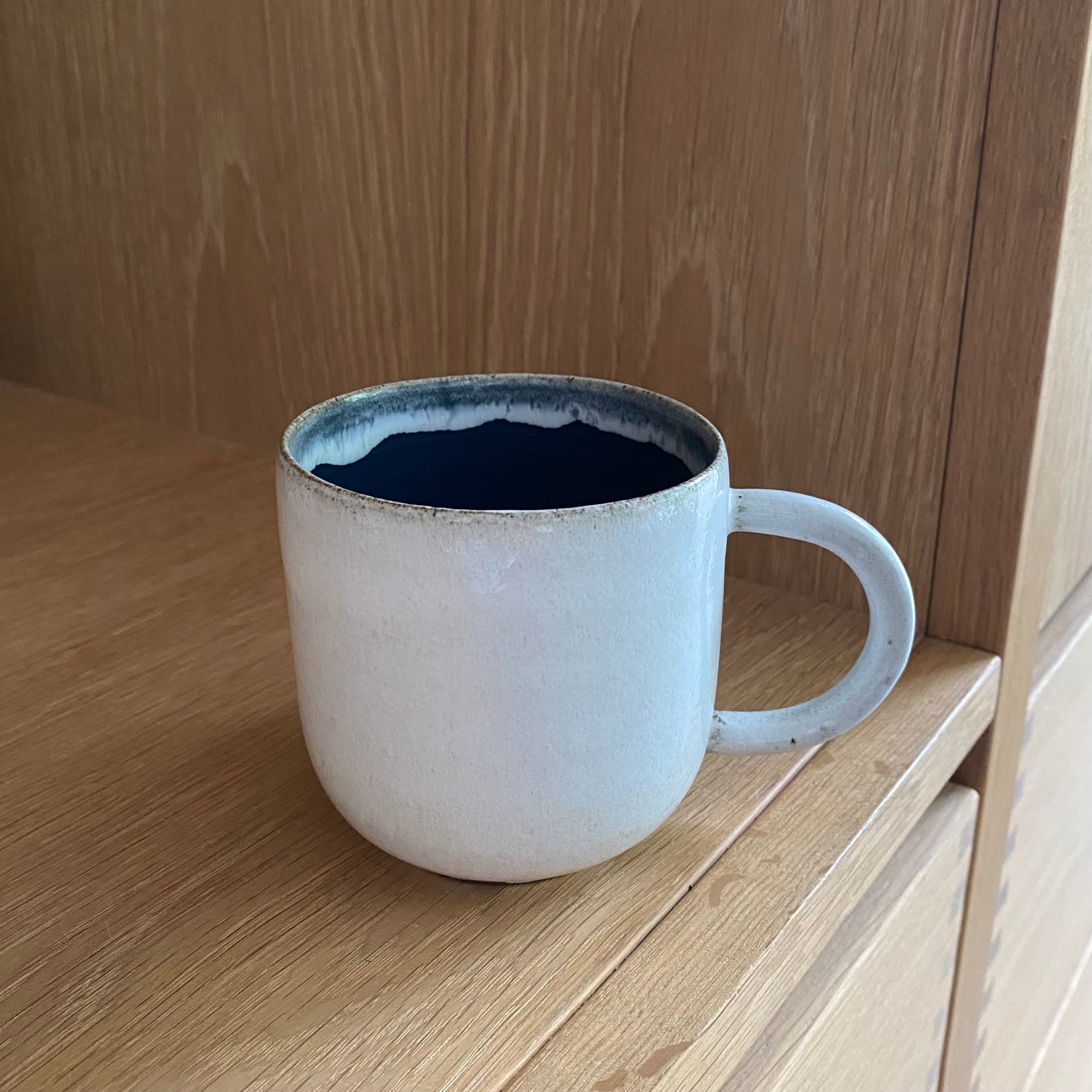 Keramikkop med hank i mørkeblå – håndlavet stentøj med off white yderside fra Tasja P ceramics