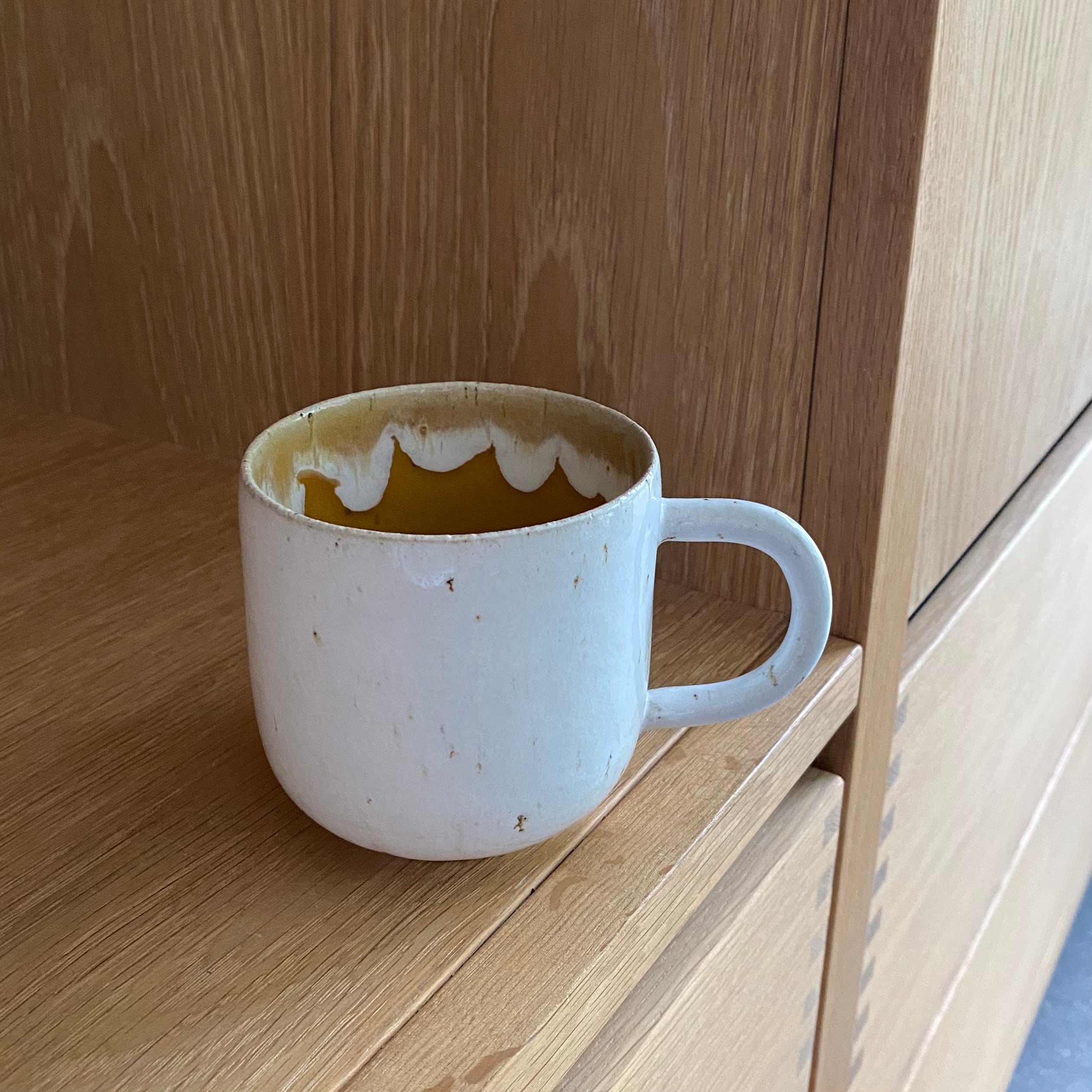 Keramikkop med hank i hvid og gul glasur – håndlavet kaffekop fra Tasja P ceramics