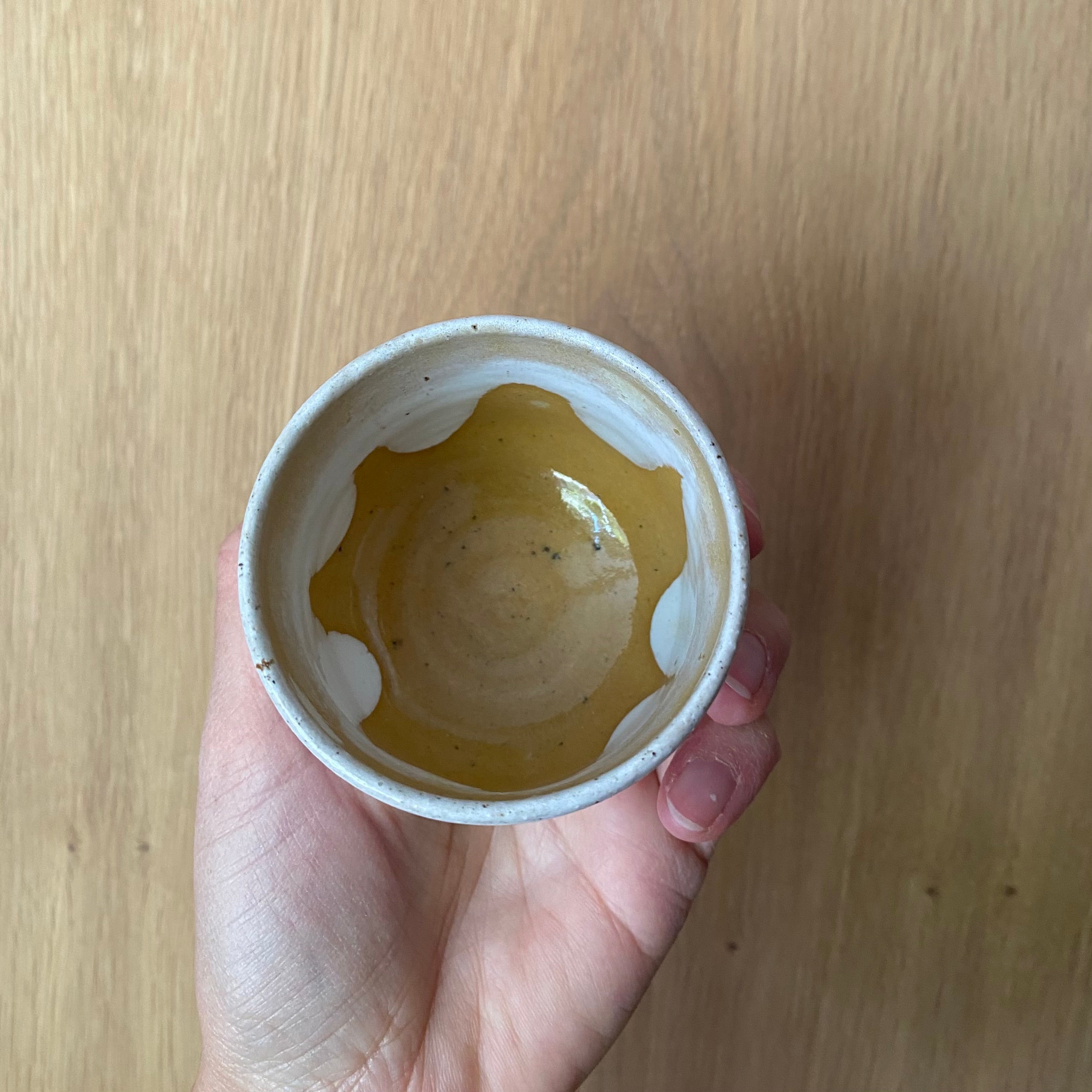 Hånddrejet espressokop i gul keramik set oppefra – off white med gul glasur indeni af Tasja P
