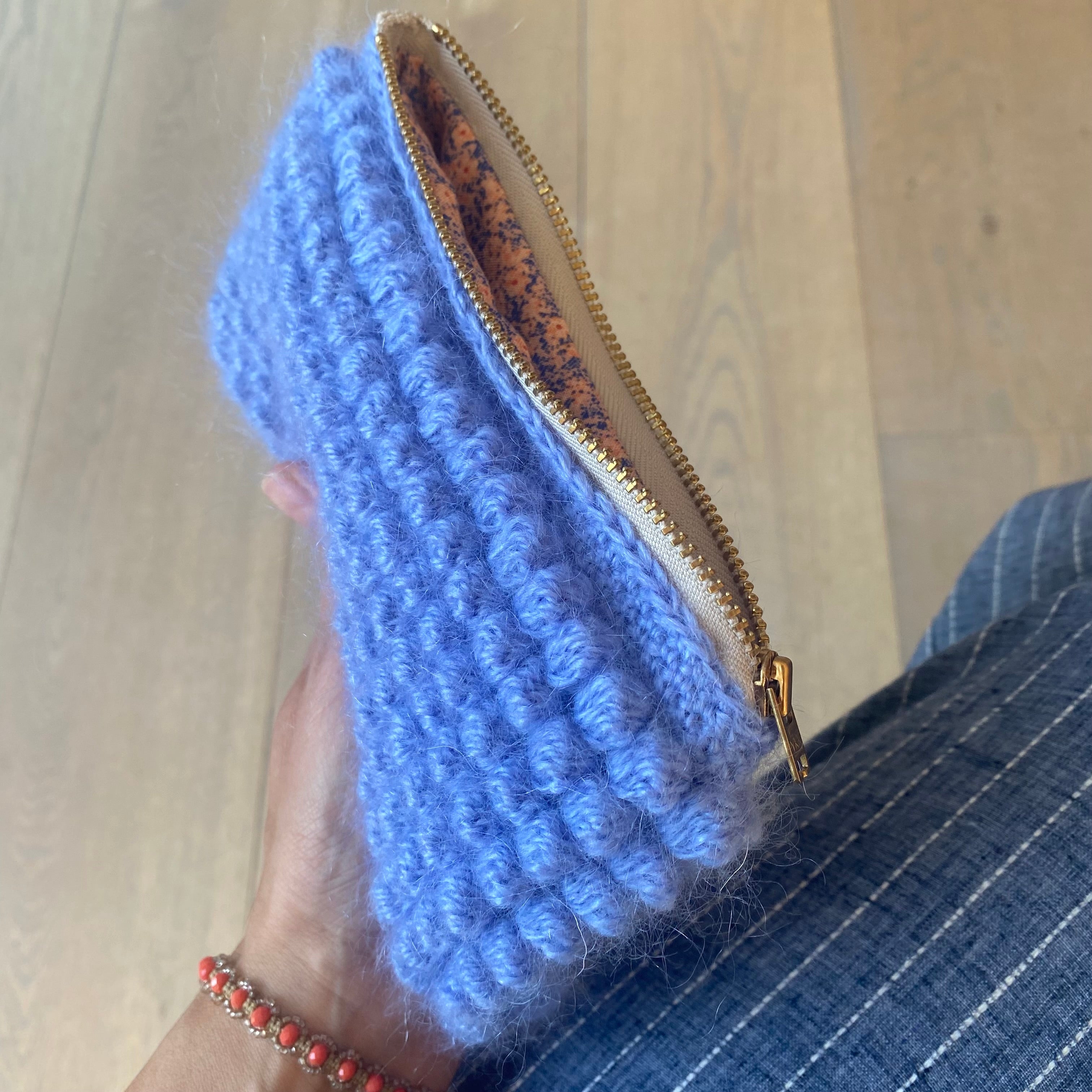 Håndhæklet lavendel clutch i bobledesign – Marie – holdt i hånden