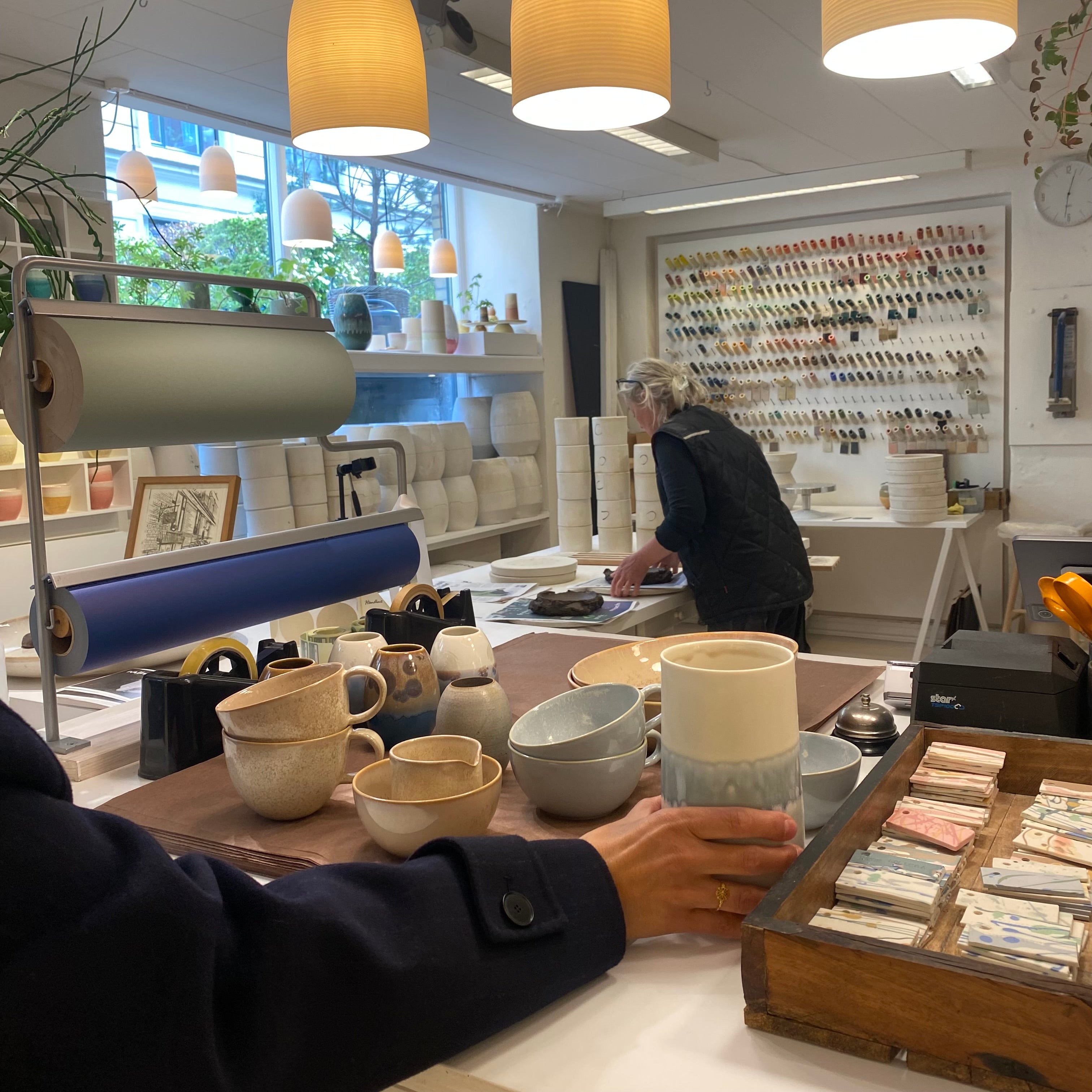 Håndlavet keramik fra Wauw Design med keramiker Sussi Krull i baggrunden