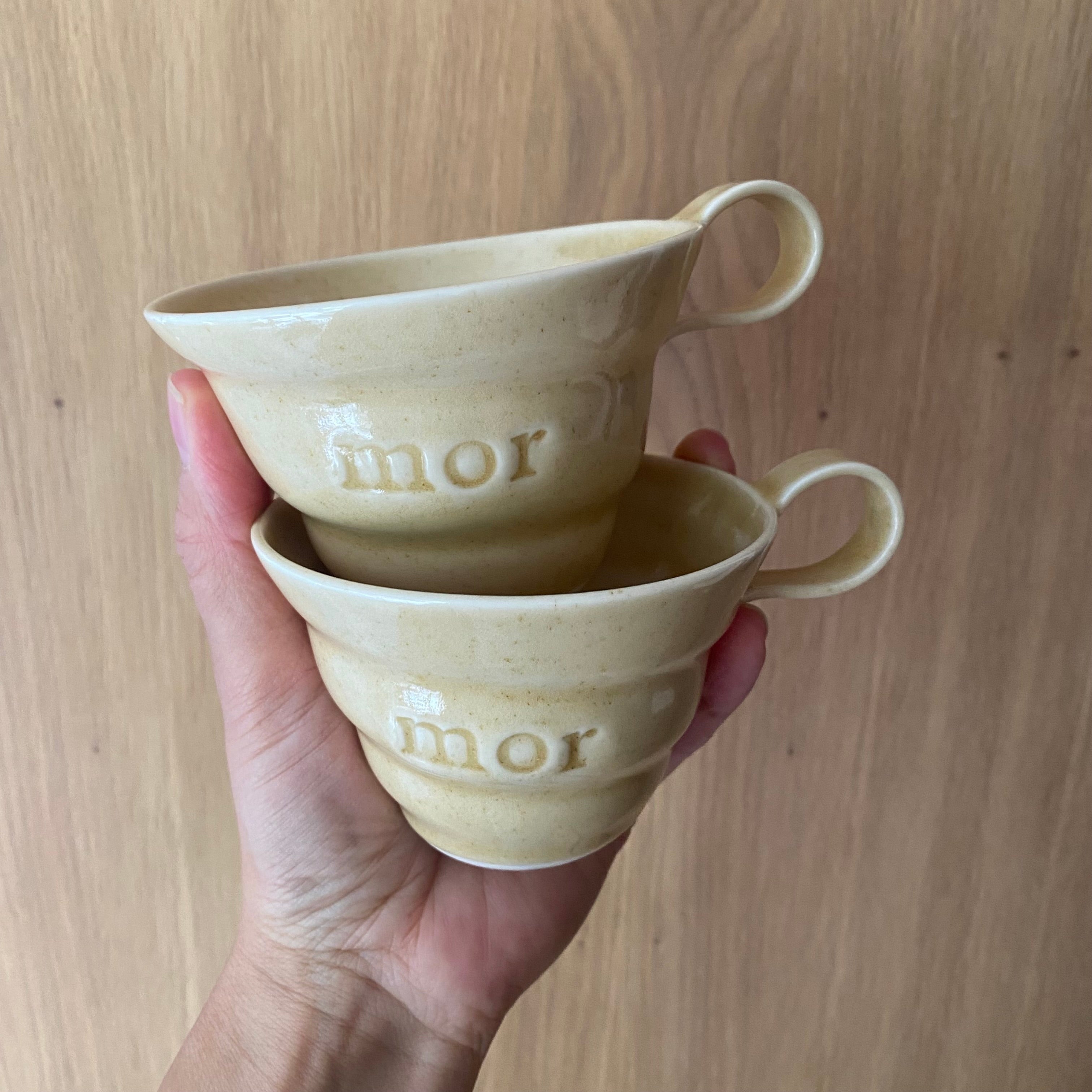 To gule mor kopper holdt i hånden – hånddrejet navnekop i porcelæn fra Rikke Mangelsen hos Unika K