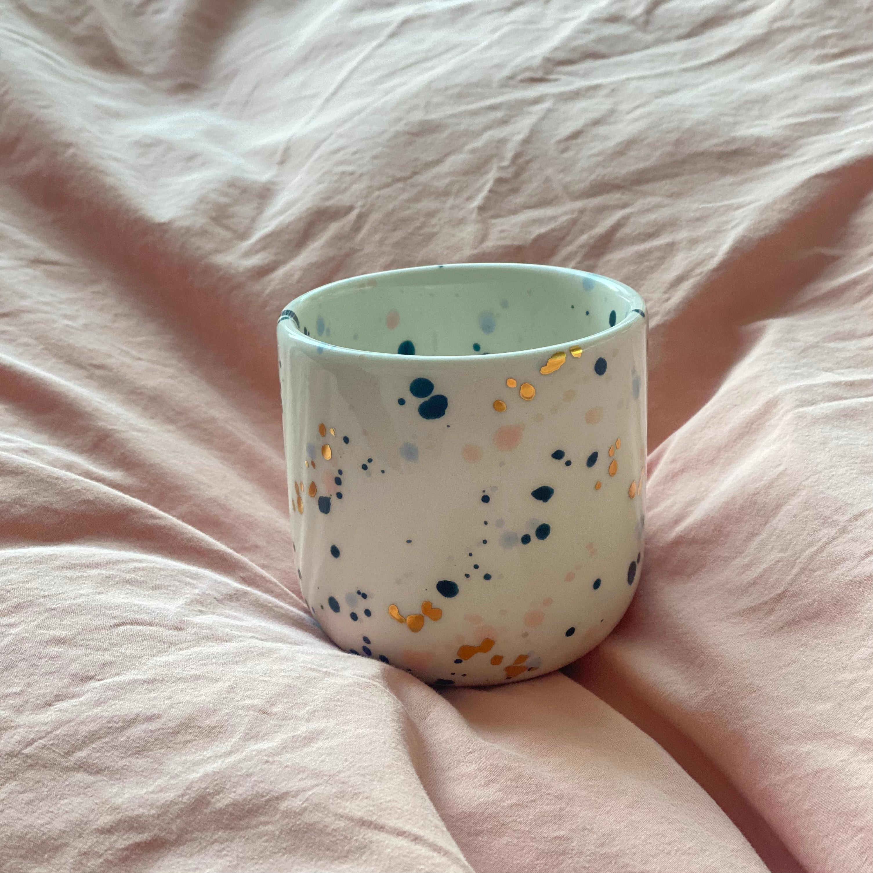 Håndlavet cappuccinokop set oppefra med farvede prikker og indvendig dekoration