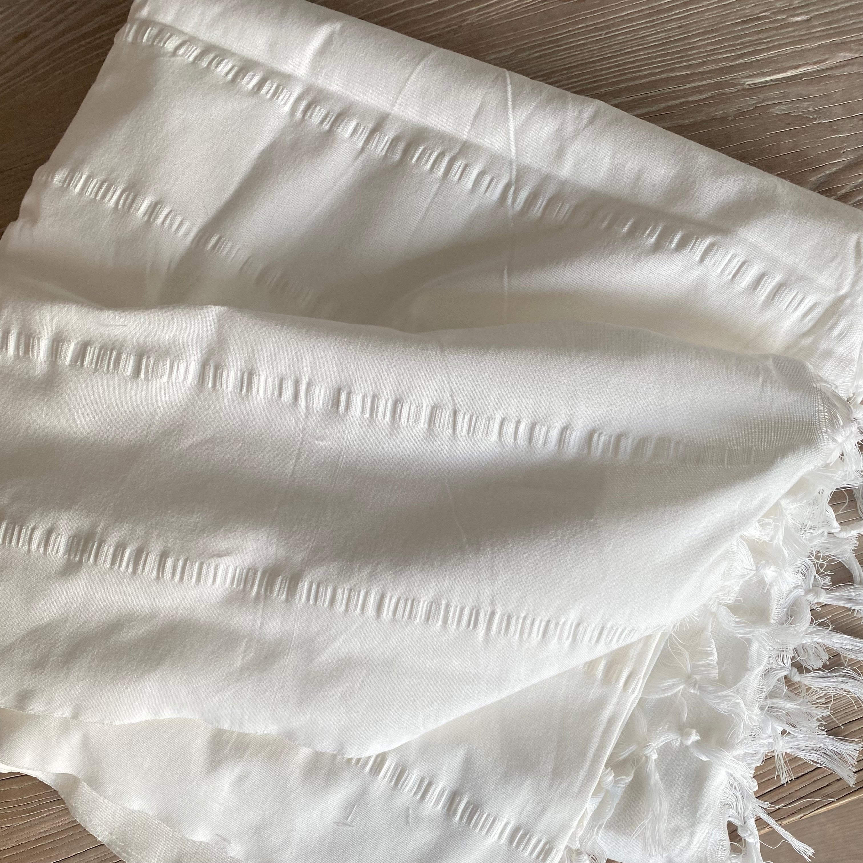 Detalje af håndvævet ensfarvet hvid dug