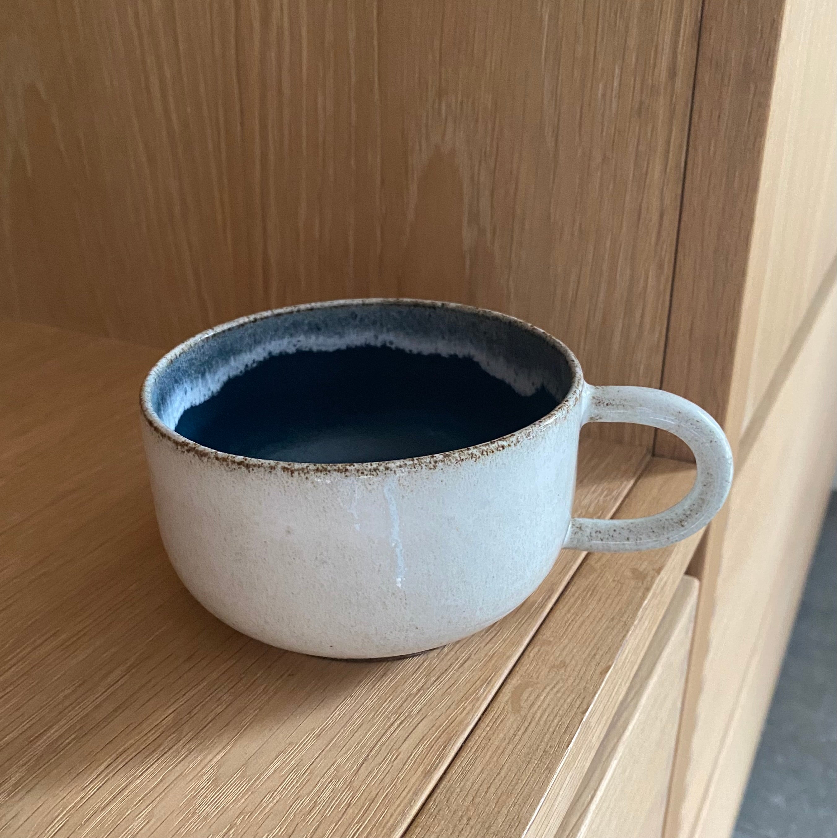 Hånddrejet kaffekop med hank i mørkeblå keramik