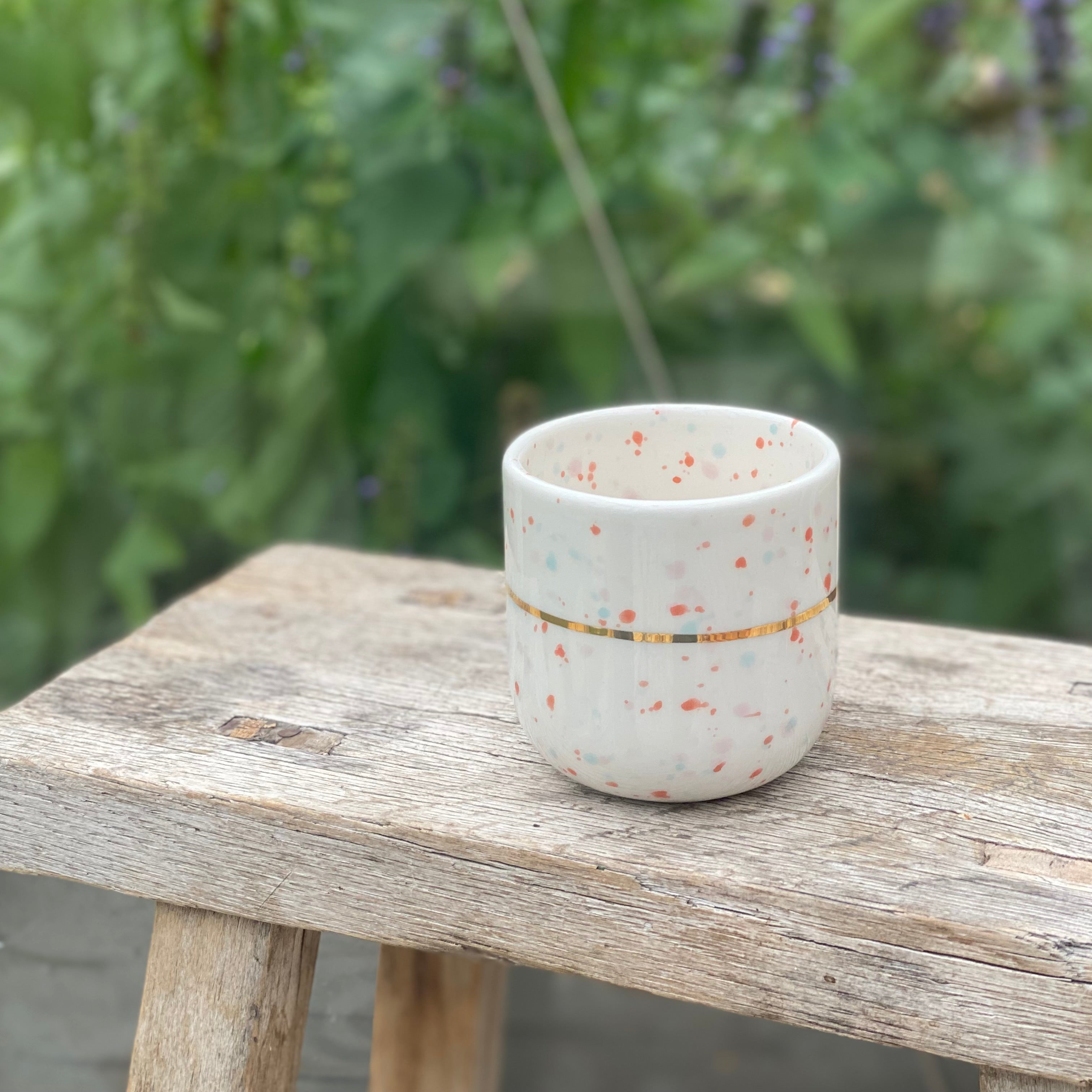 Lattekop i hvid keramik med håndmalede prikker og guldbånd – unika kop fra unika:k