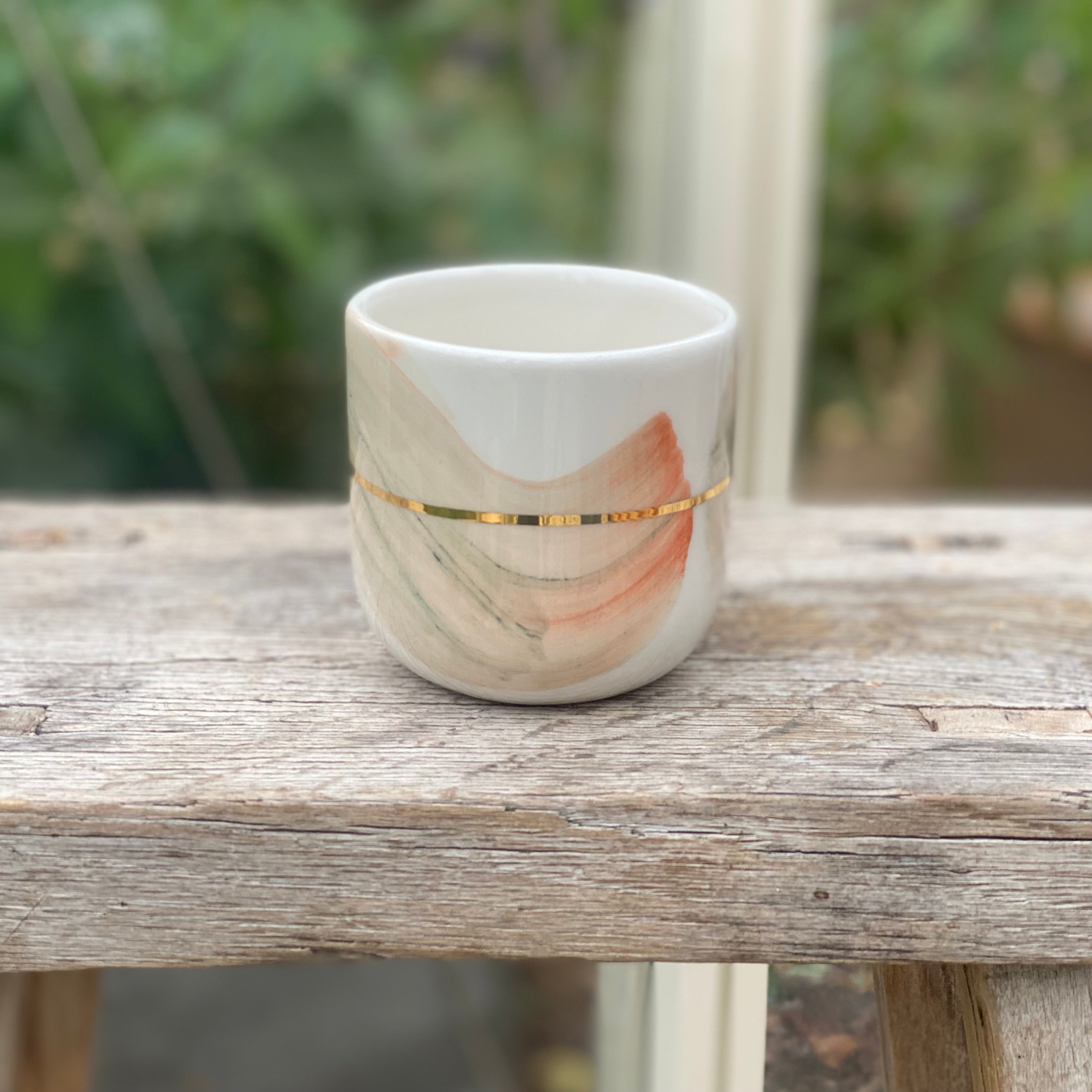 Keramikkop med håndmalede penselstrøg i mint og coral nuancer med gulddetaljer – dansk design
