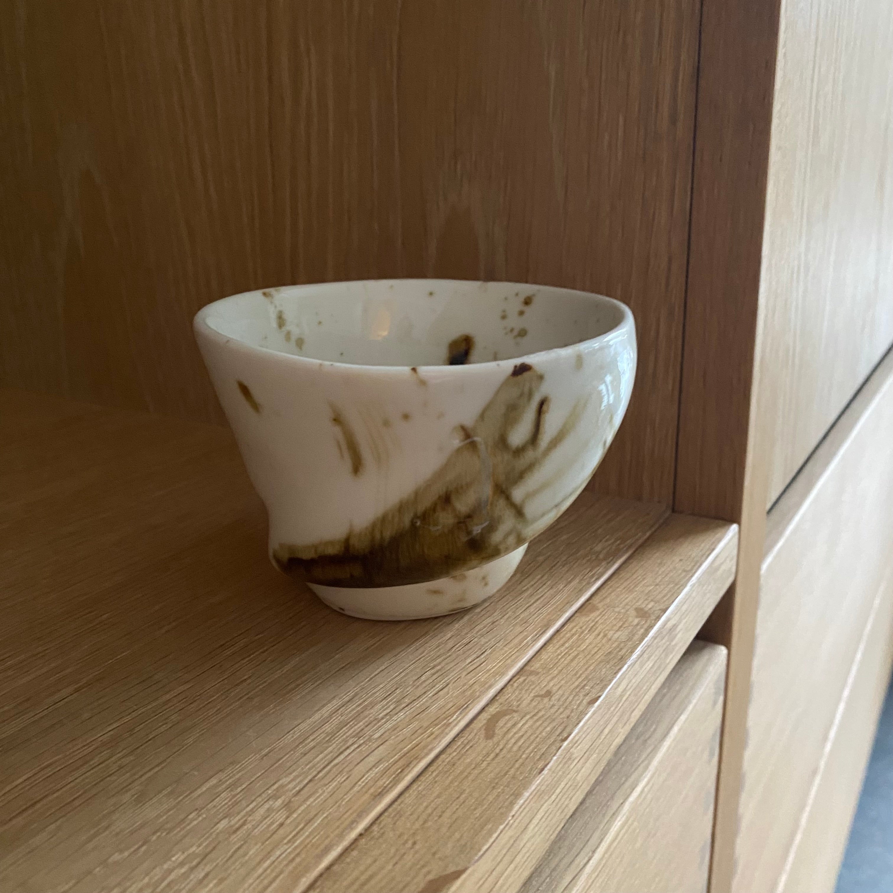 håndlavet keramikkop der hedder sort sol. Den er i hvid og mørkebrun