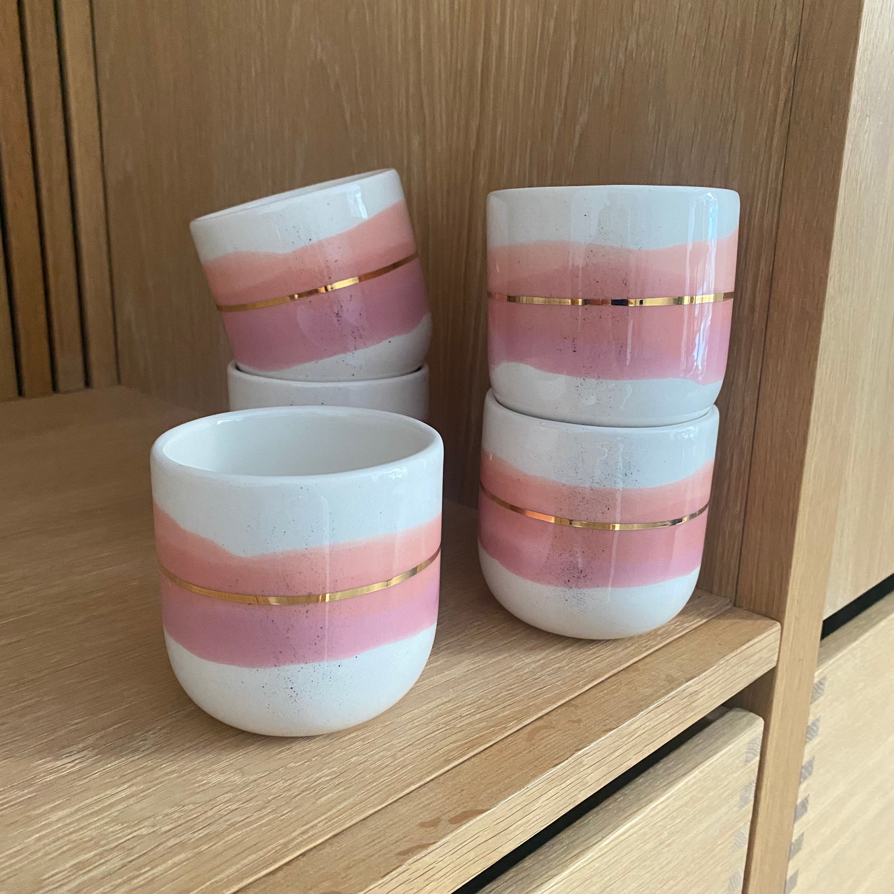 Håndlavet keramikkop i koral og lyserød og med gulddetalje 