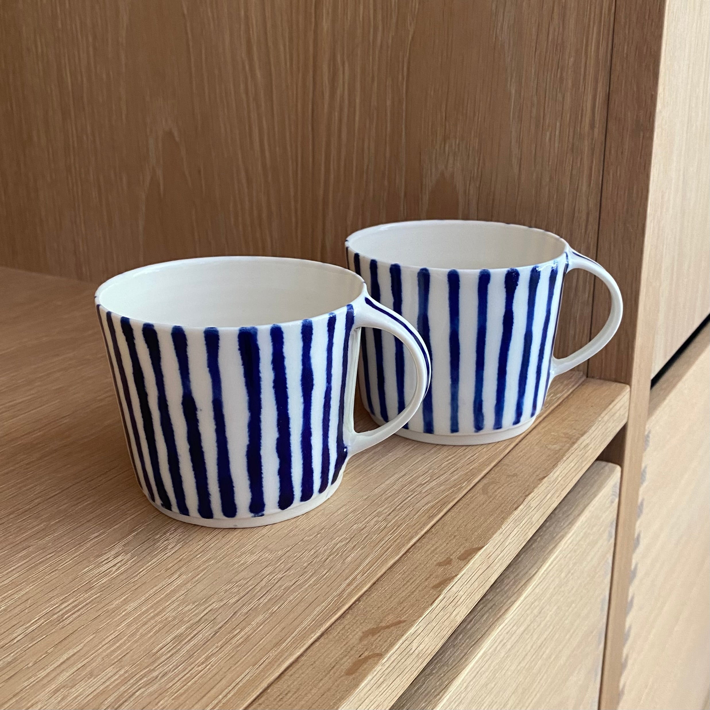 Keramikkop i hvid porcelæn med blå striber – hånddrejet og unik